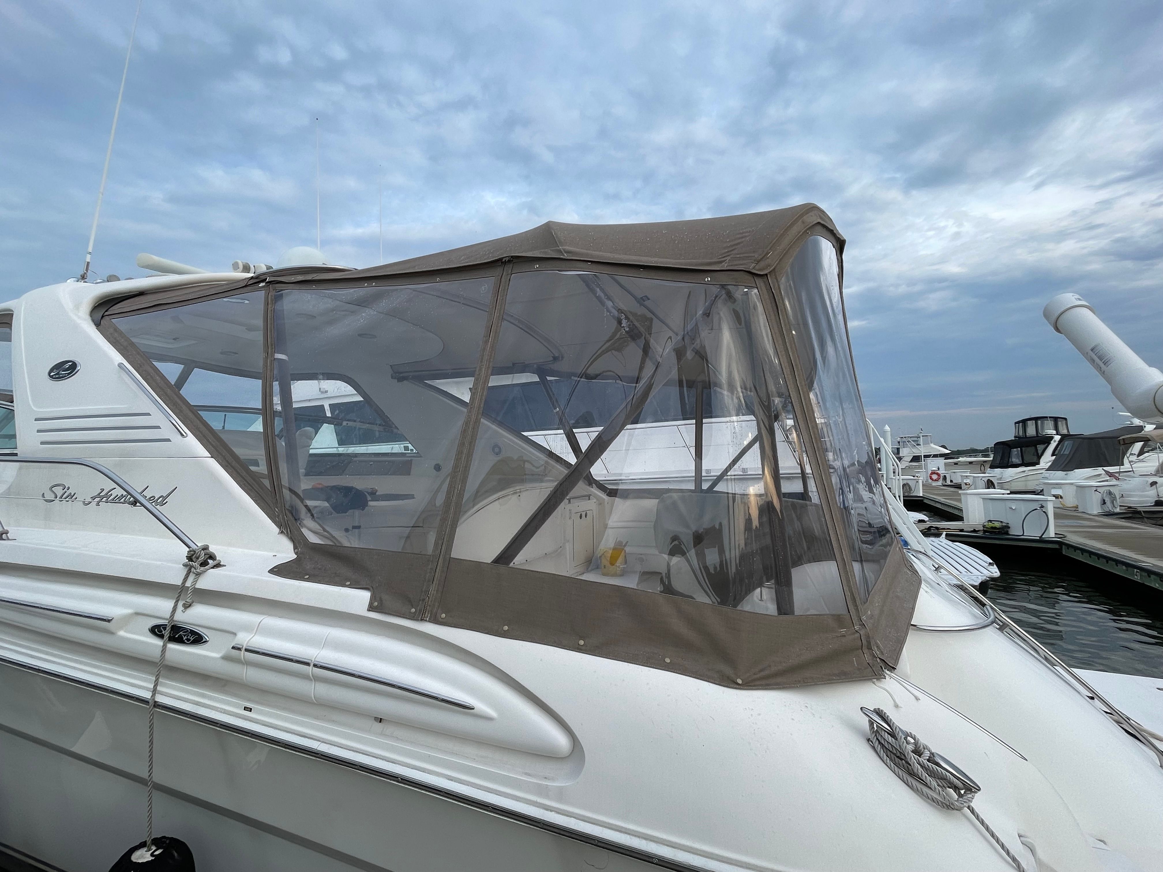 A 2003 Sea Ray S600 Sunsport with a canopy, docked at a marina.
