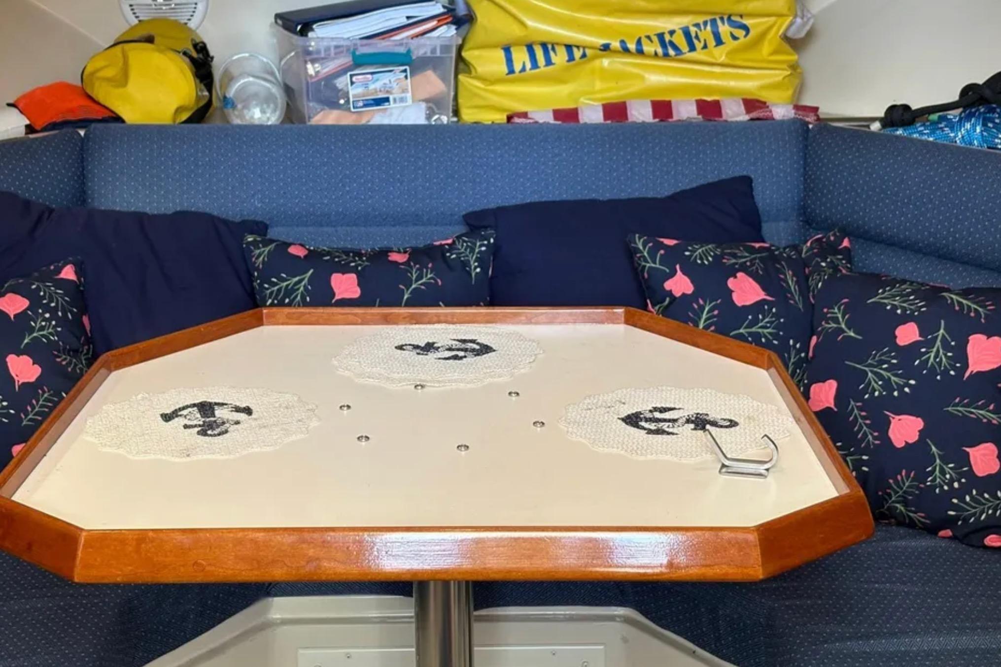 Interior of 2005 Albin 28 Tournament Express with floral cushions and wooden table.