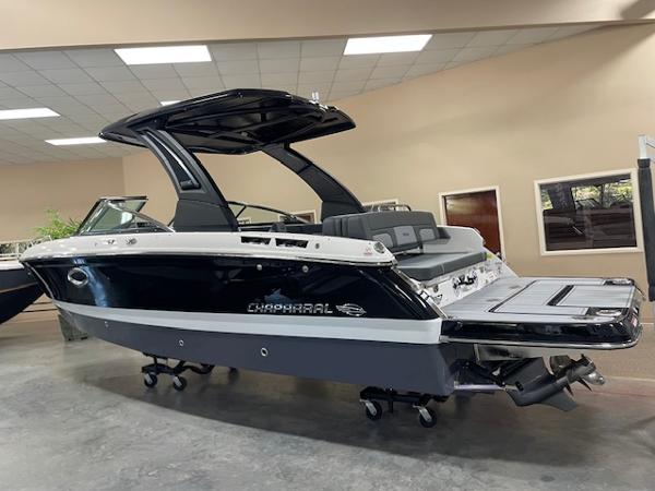 2025 Chaparral 267 SSX boat in showroom, sleek black and white design.