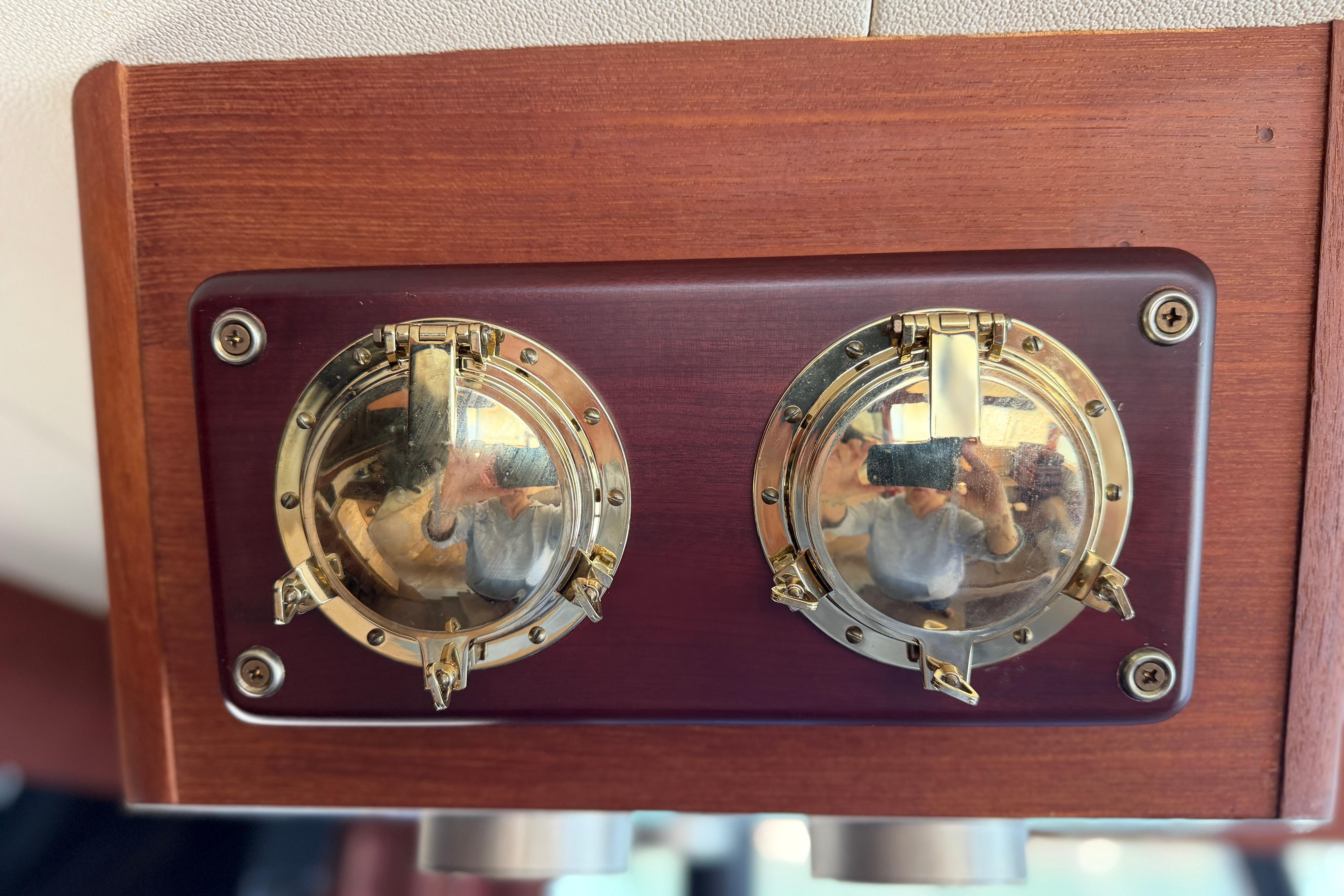 Brass nautical gauges on 1994 Bayliner 3888 MY Sedan's wooden panel.