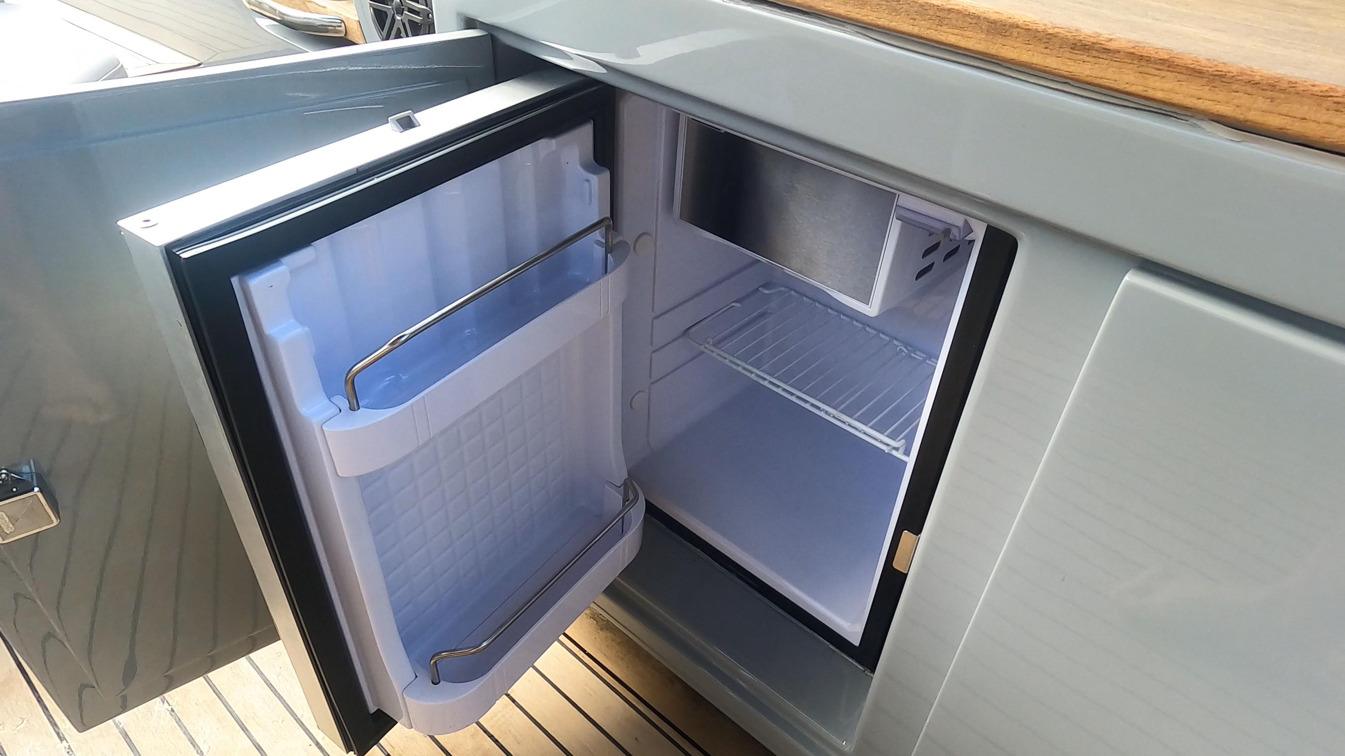 Open mini fridge on Rand Leisure 2021 boat, showcasing interior storage space.