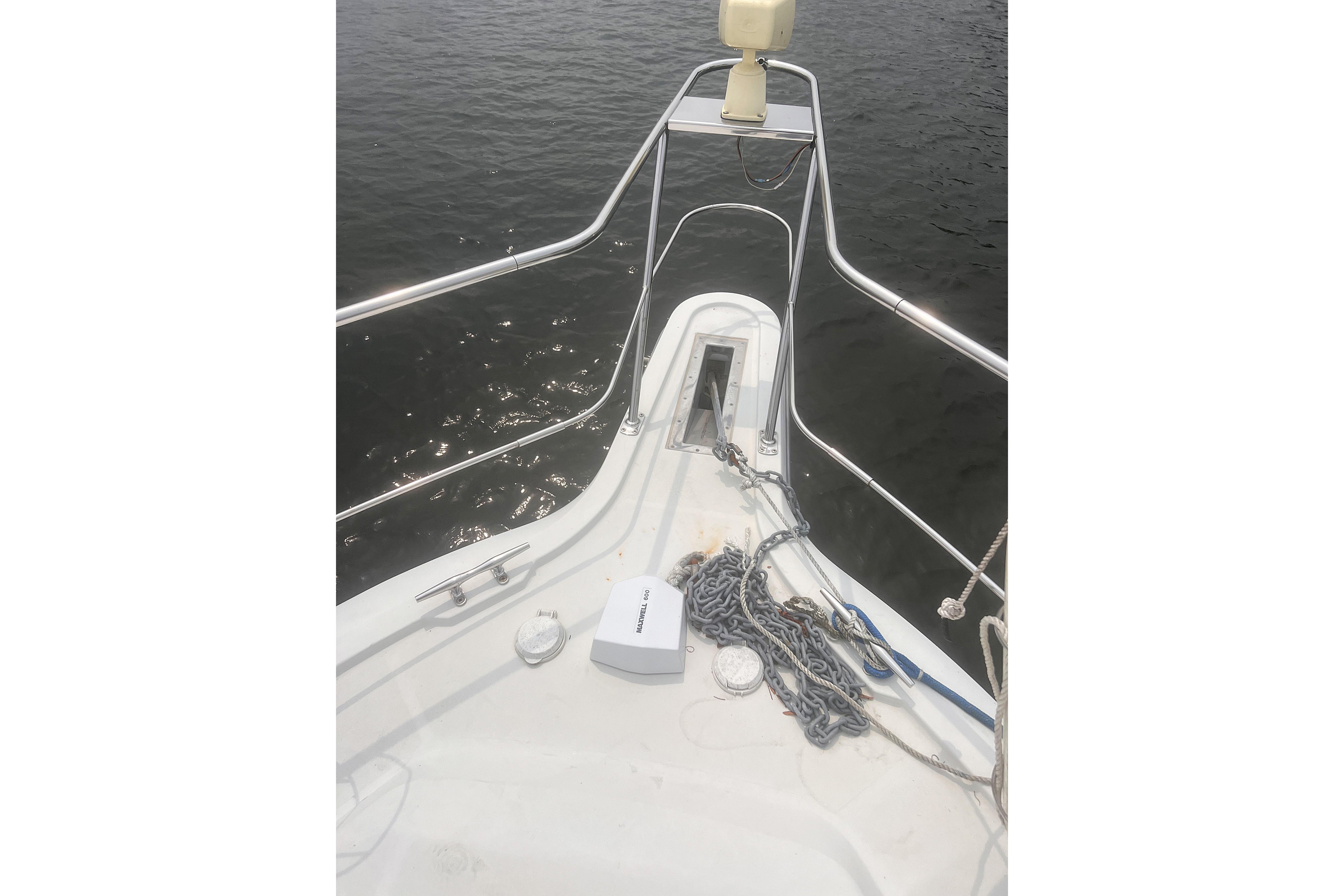 Bow of 1994 Carver 350 yacht with anchor chain and calm water view.