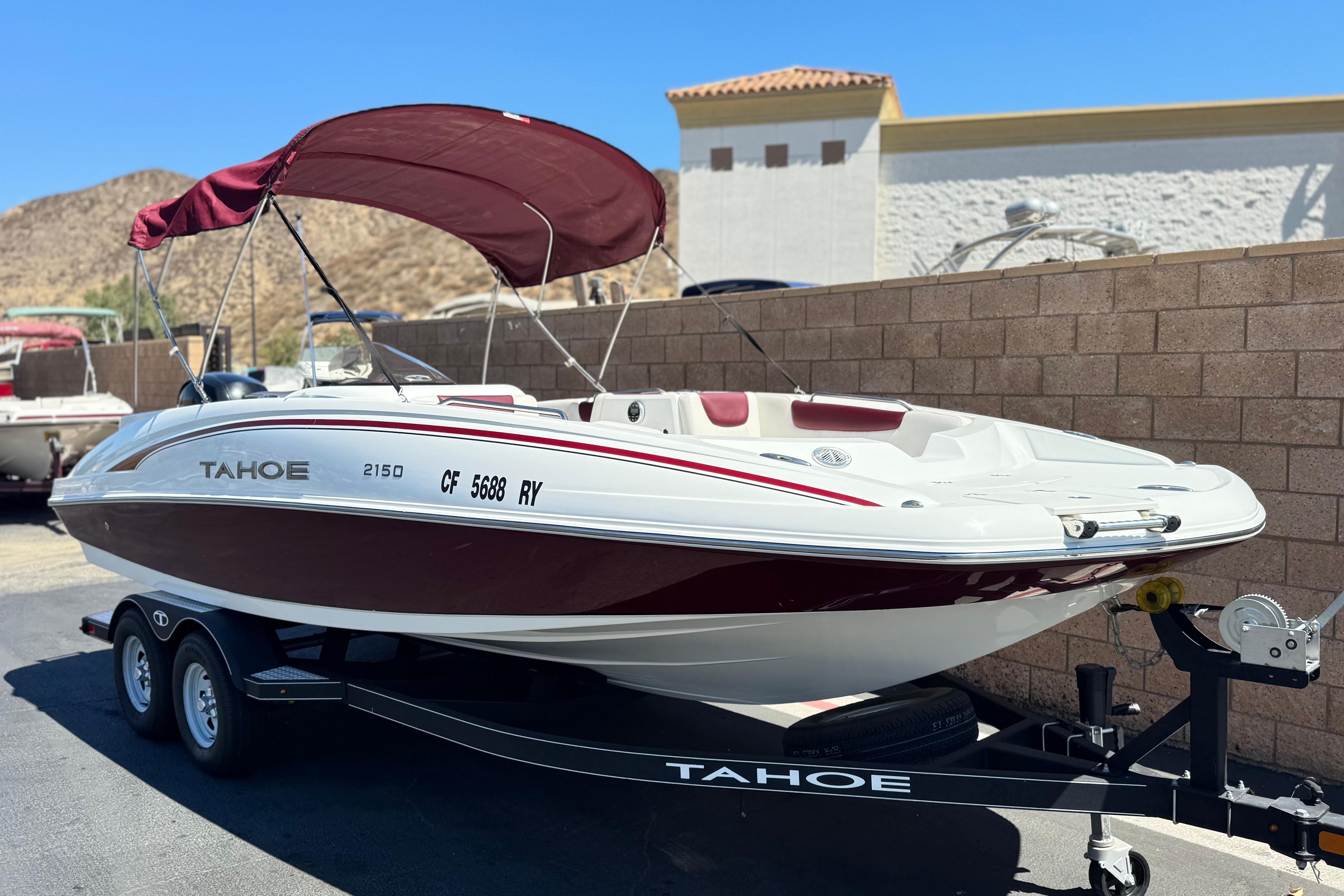 2017 Tahoe 2150 boat with maroon canopy on trailer, parked outdoors.