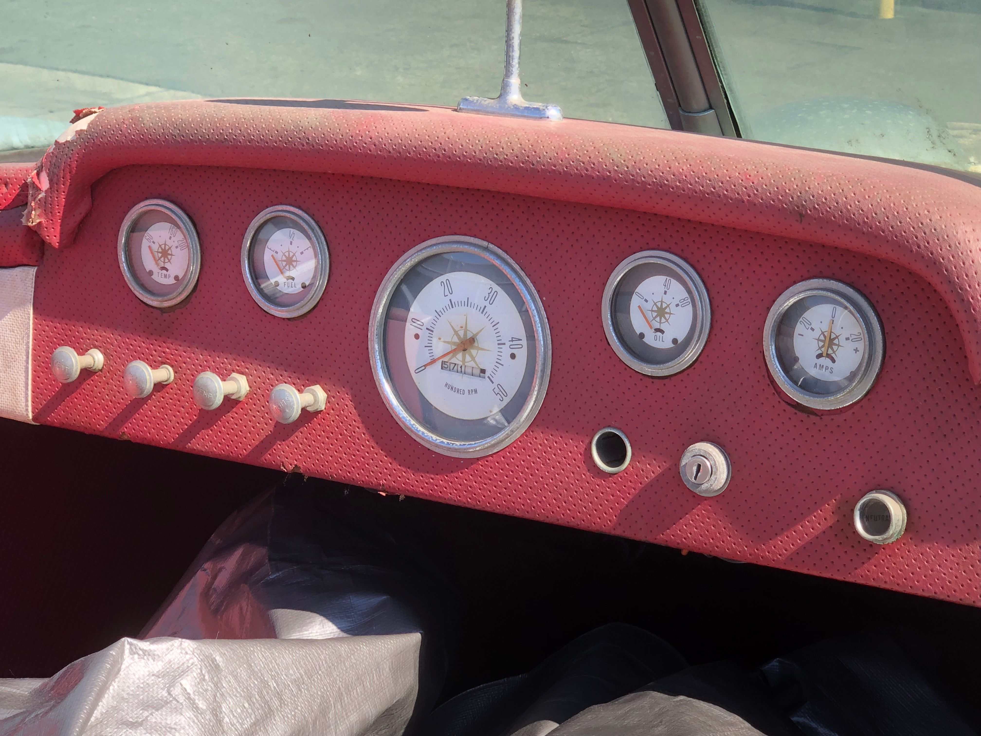 Dashboard of a 1960 Century Resorter with classic round gauges and red upholstery.