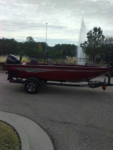 2024 Ranger VS1665T boat on trailer, parked near a fountain and trees.