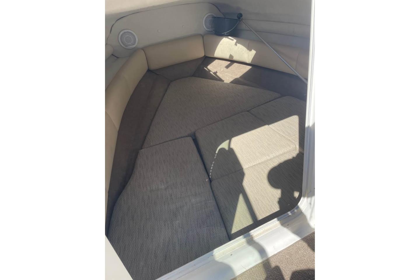 2007 Chaparral 215 SSi boat interior cabin with cushioned seating and speakers.
