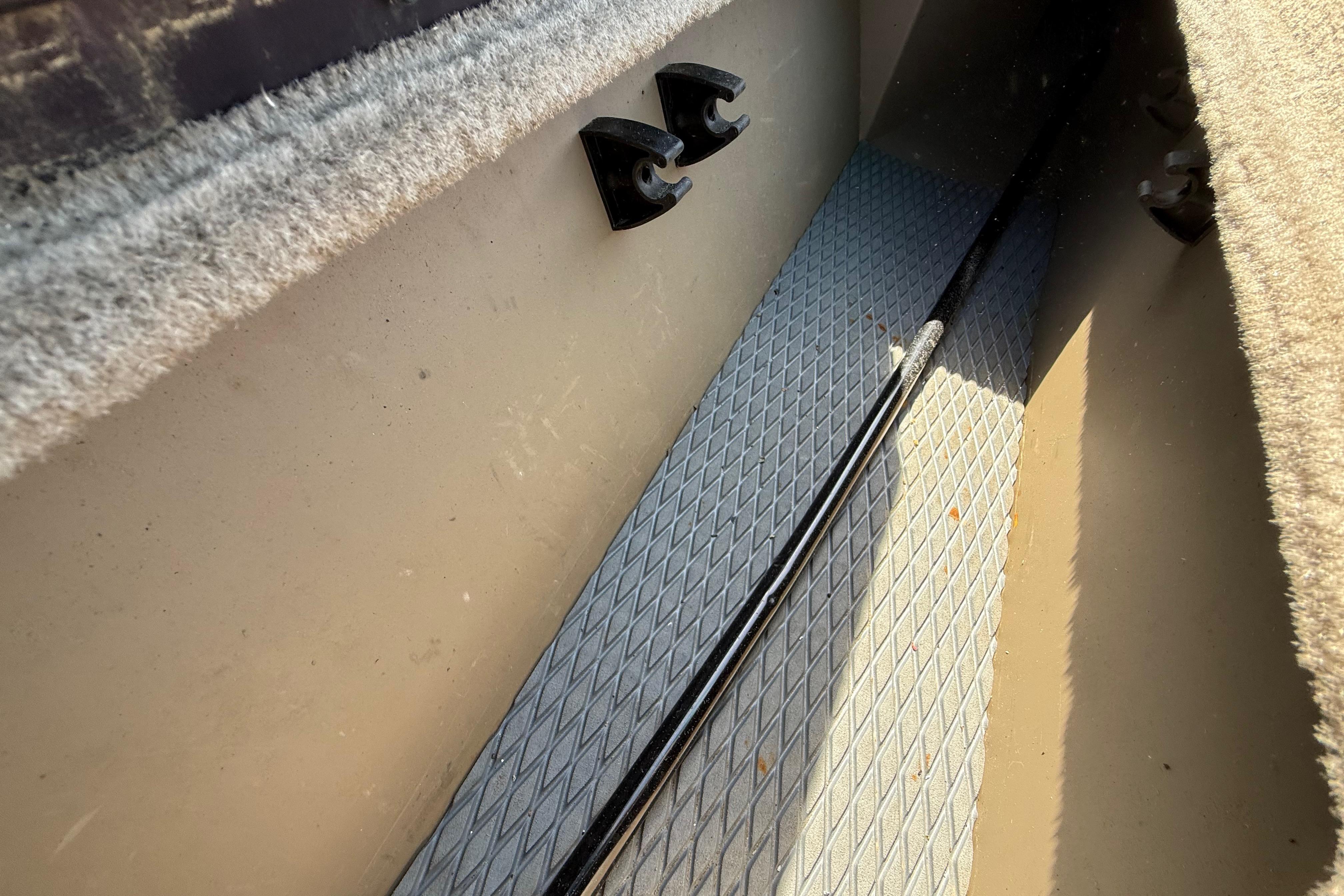 Interior view of a 2010 SeaArk Stealth 190 boat, featuring carpeted surfaces and rod storage.
