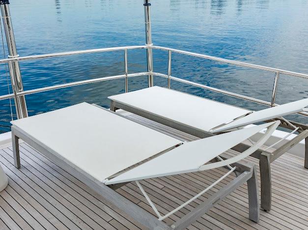 Sun loungers on the deck of a 2015 Hatteras 100 Raised Pilothouse yacht.