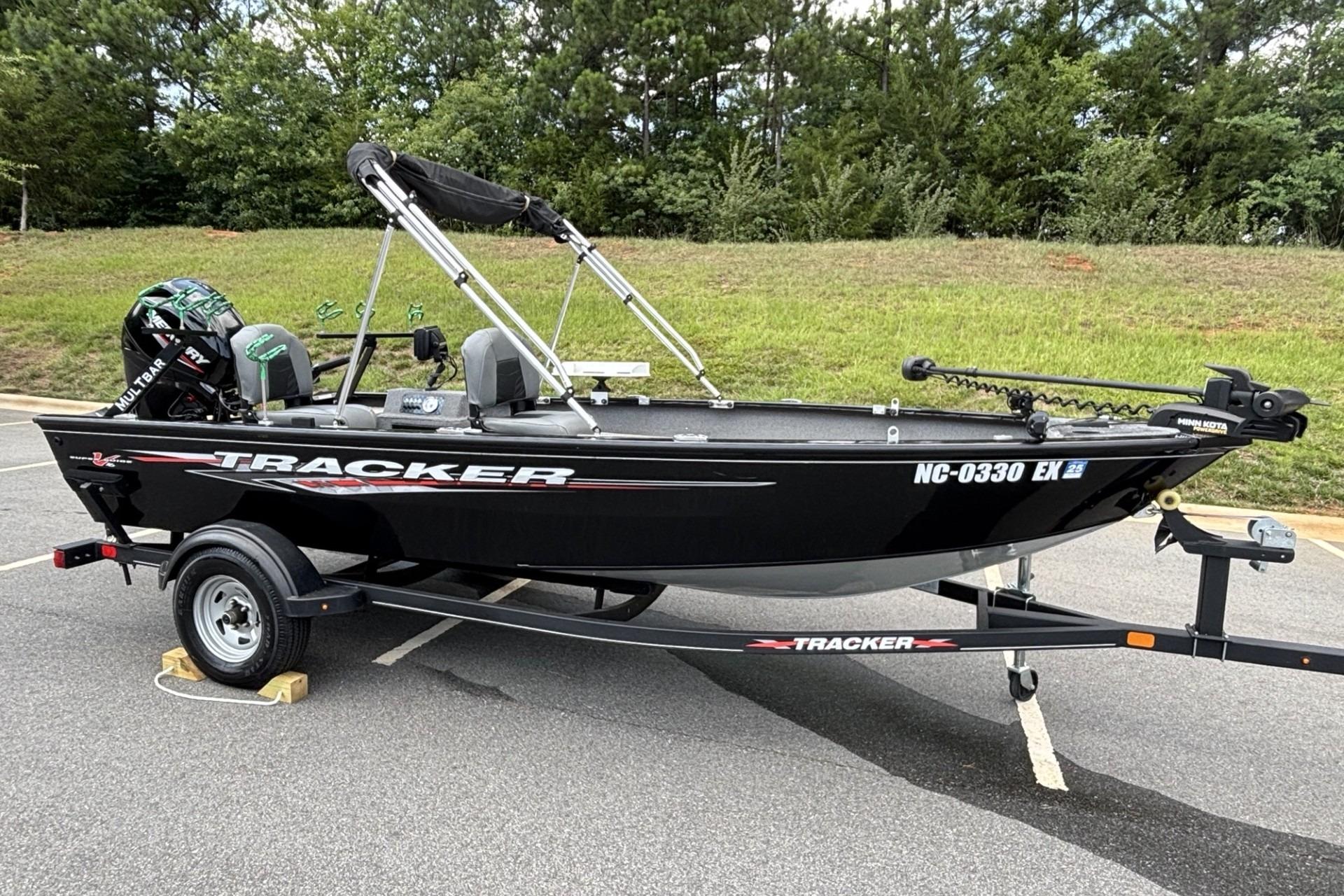2022 Tracker Super Guide V-16 T boat on trailer in parking lot.