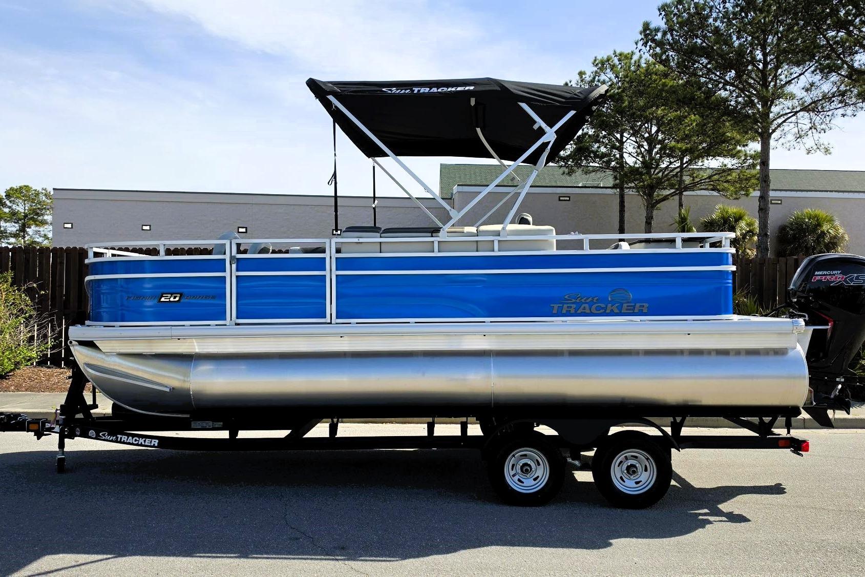 2026 Sun Tracker Fishin' Barge 20 DLX pontoon boat on trailer, side view.