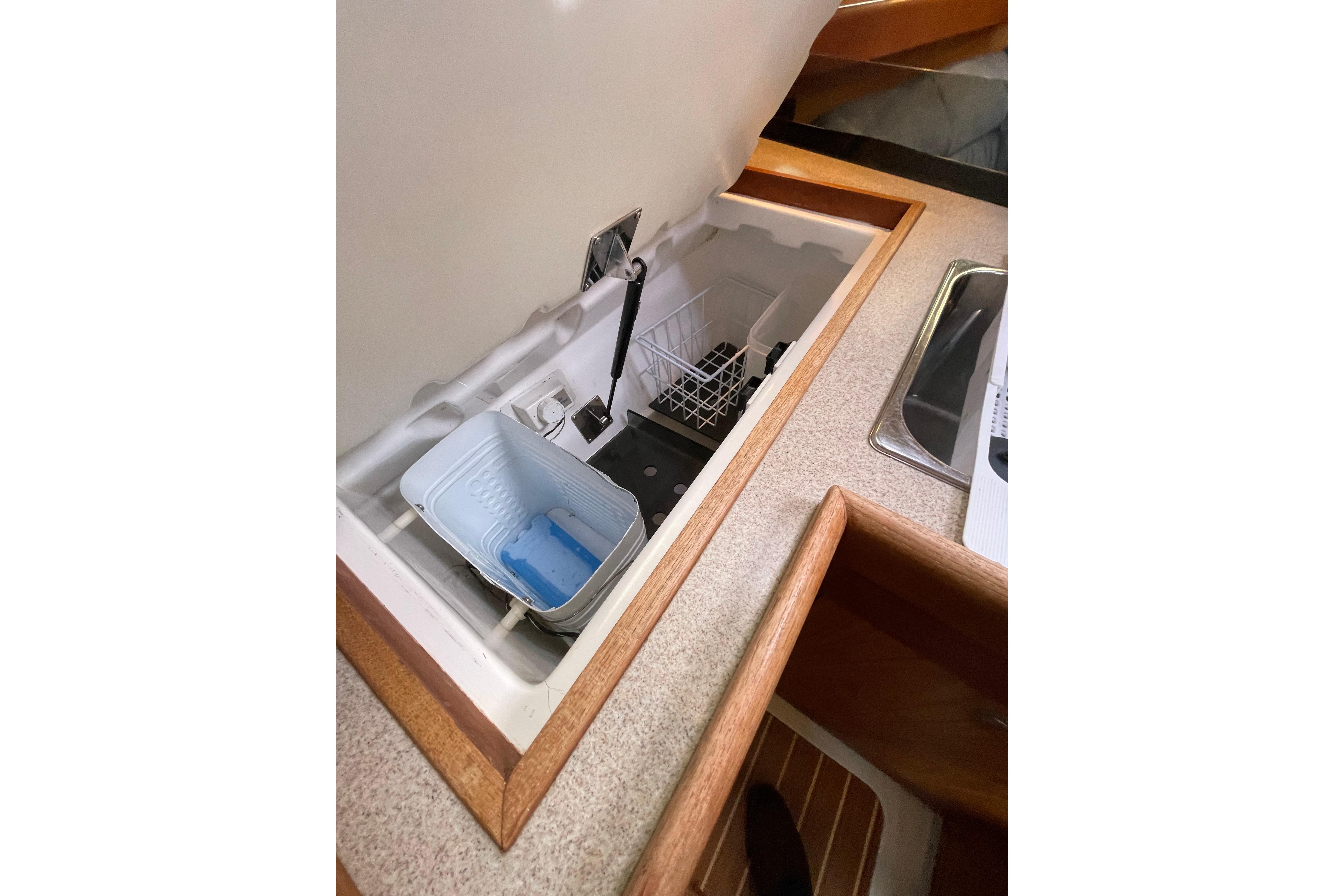 Interior view of a 2000 Hunter 340 sailboat kitchen with open storage compartment.