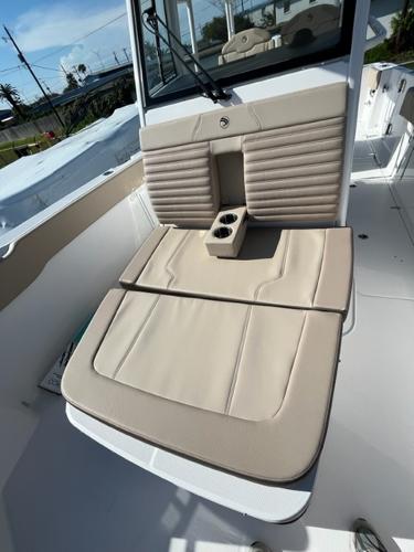 2023 Edgewater 340CC boat with beige cushioned seating and cup holders.