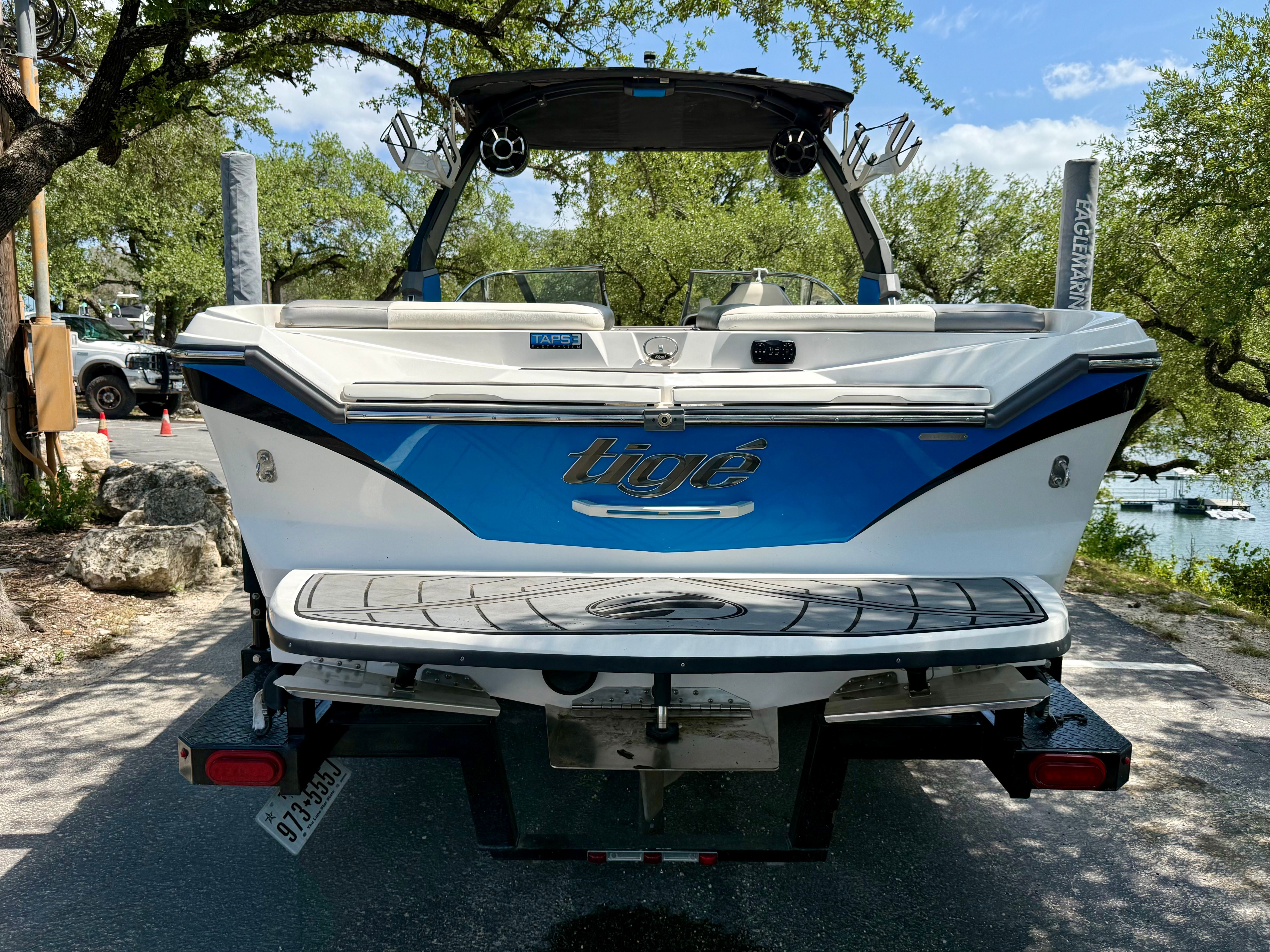 Rear view of a 2017 Tigé Z3 boat on a trailer, surrounded by trees.