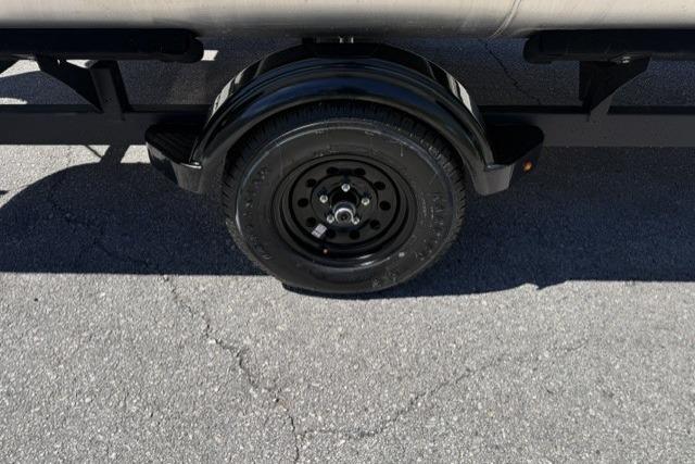 Trailer wheel of 2026 Sun Tracker Bass Buggy 16 XL Select on asphalt surface.