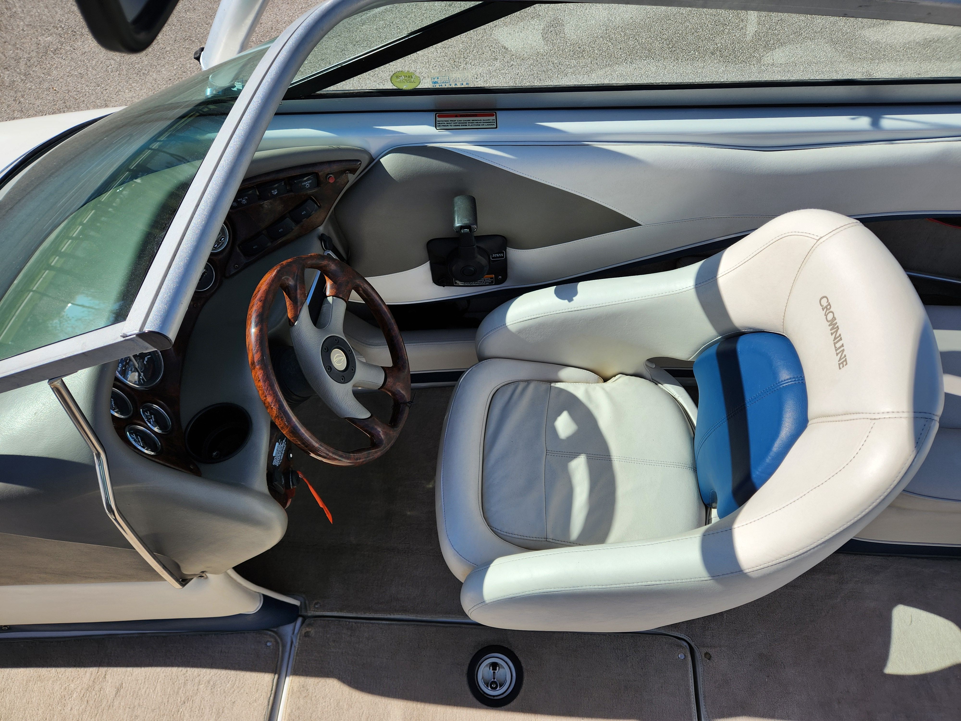 Interior of a 2003 Crownline 225 BR boat with steering wheel and seat.