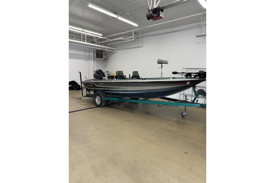 1999 Stratos 219 CF boat on trailer in indoor garage setting.