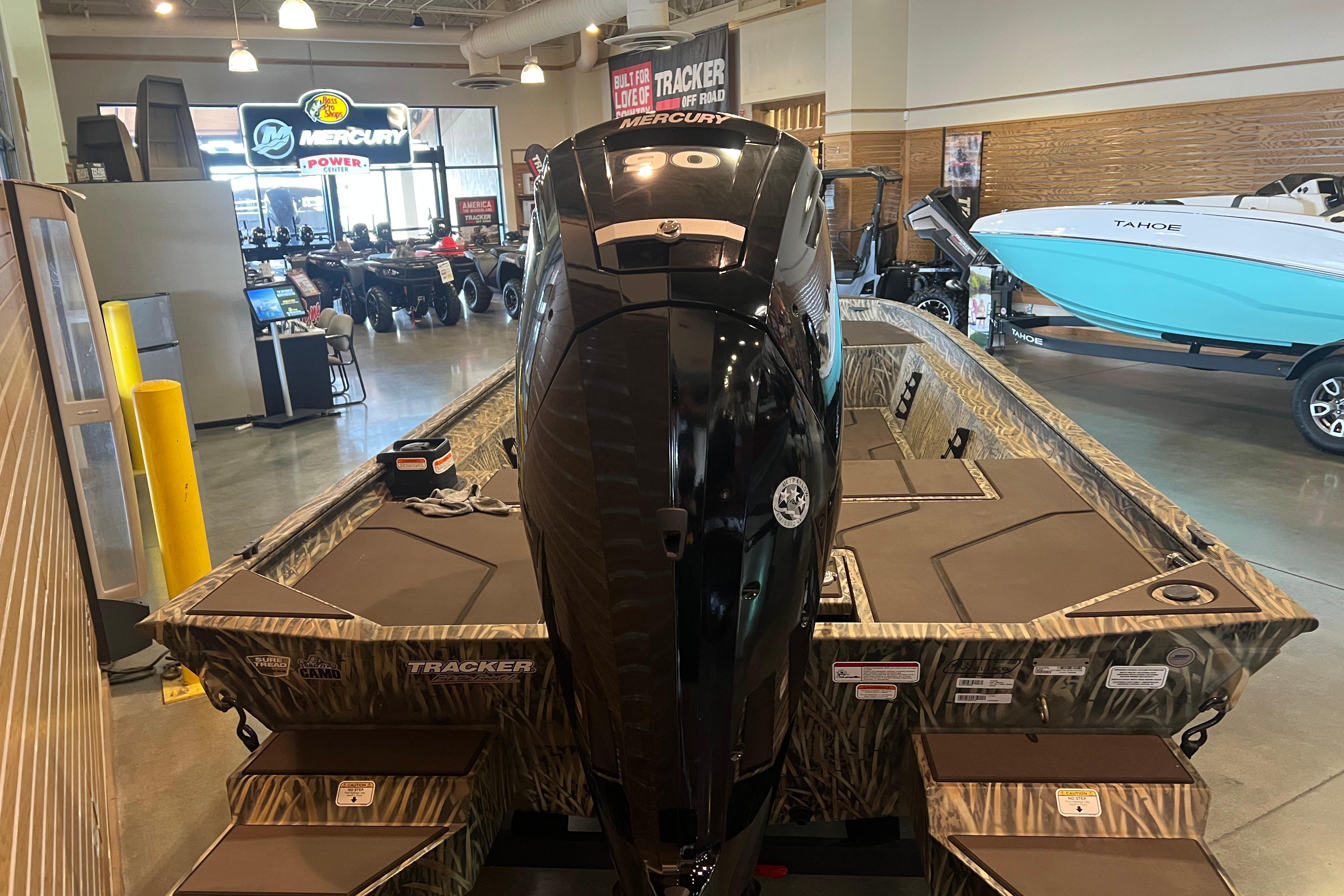2026 Tracker Grizzly 1860 CC boat with Mercury engine in showroom.