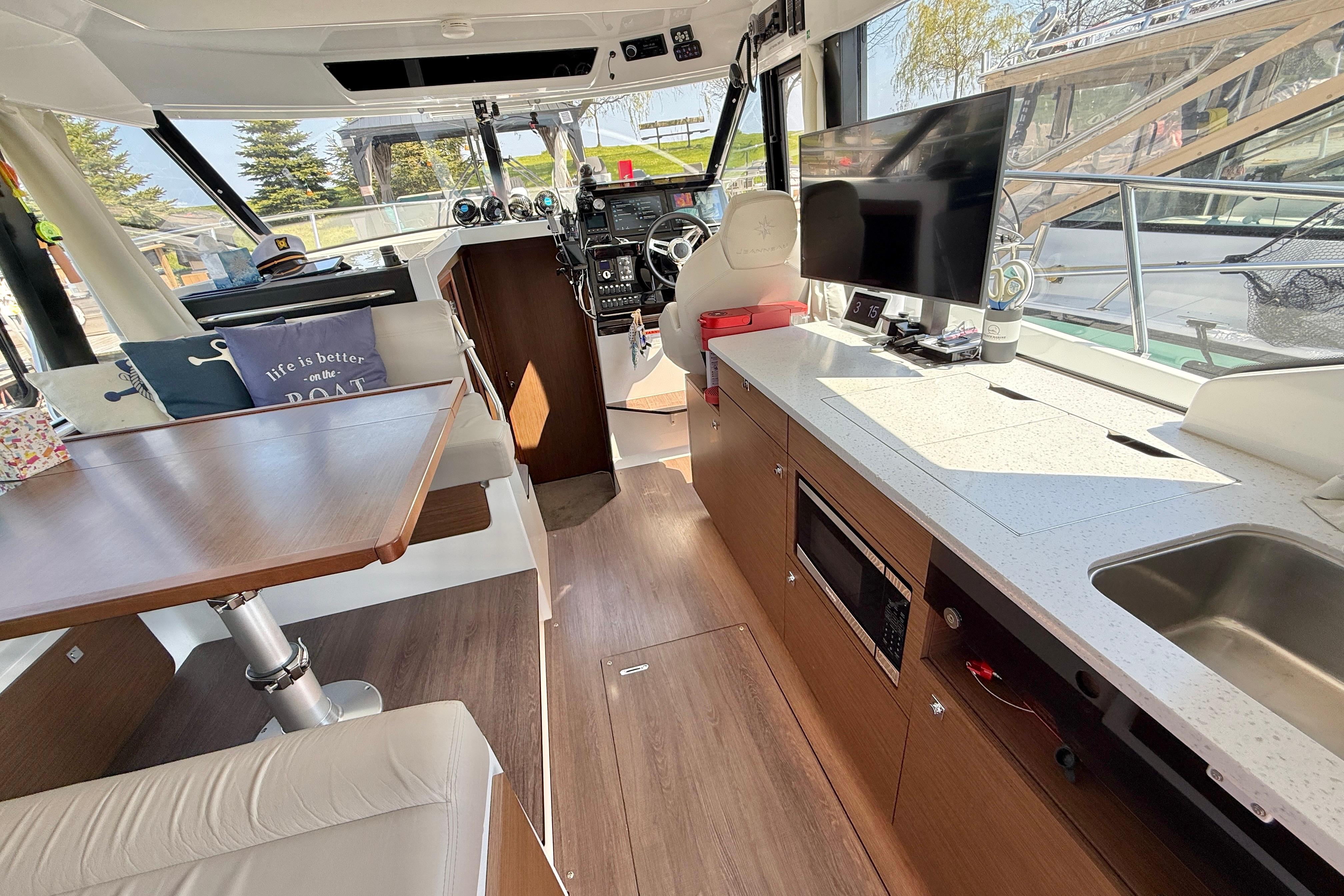 Interior of 2022 Jeanneau NC 1095 Fly yacht with modern kitchen and seating area.