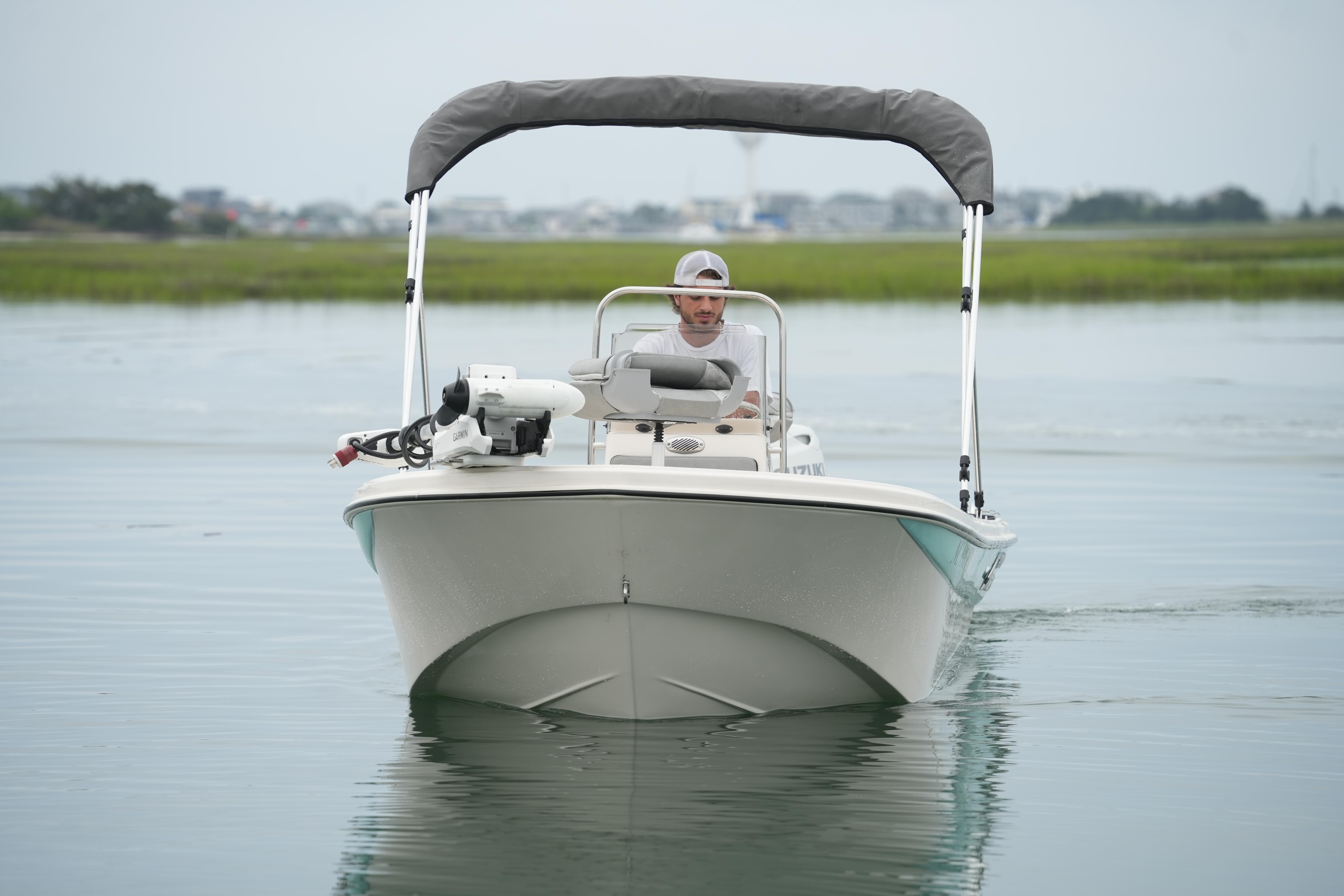 2025 Carolina Skiff 162 JLS boat on calm water with canopy and driver.