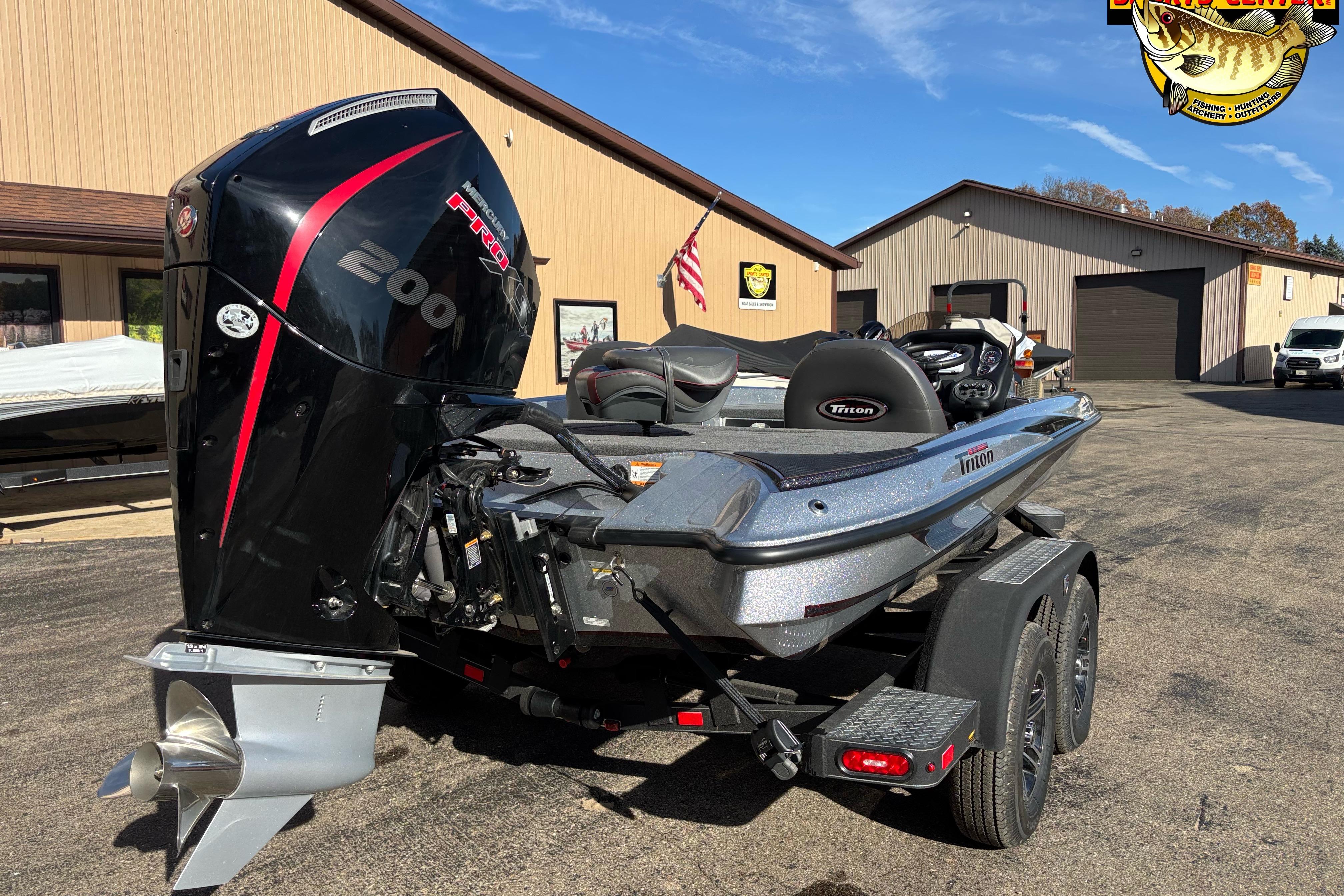 2025 Triton 18 TrX boat with powerful engine, parked outside a building.