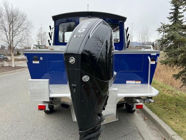 2023 Spartan 220 Maximus Pro boat with powerful V8 engine, parked on a road.