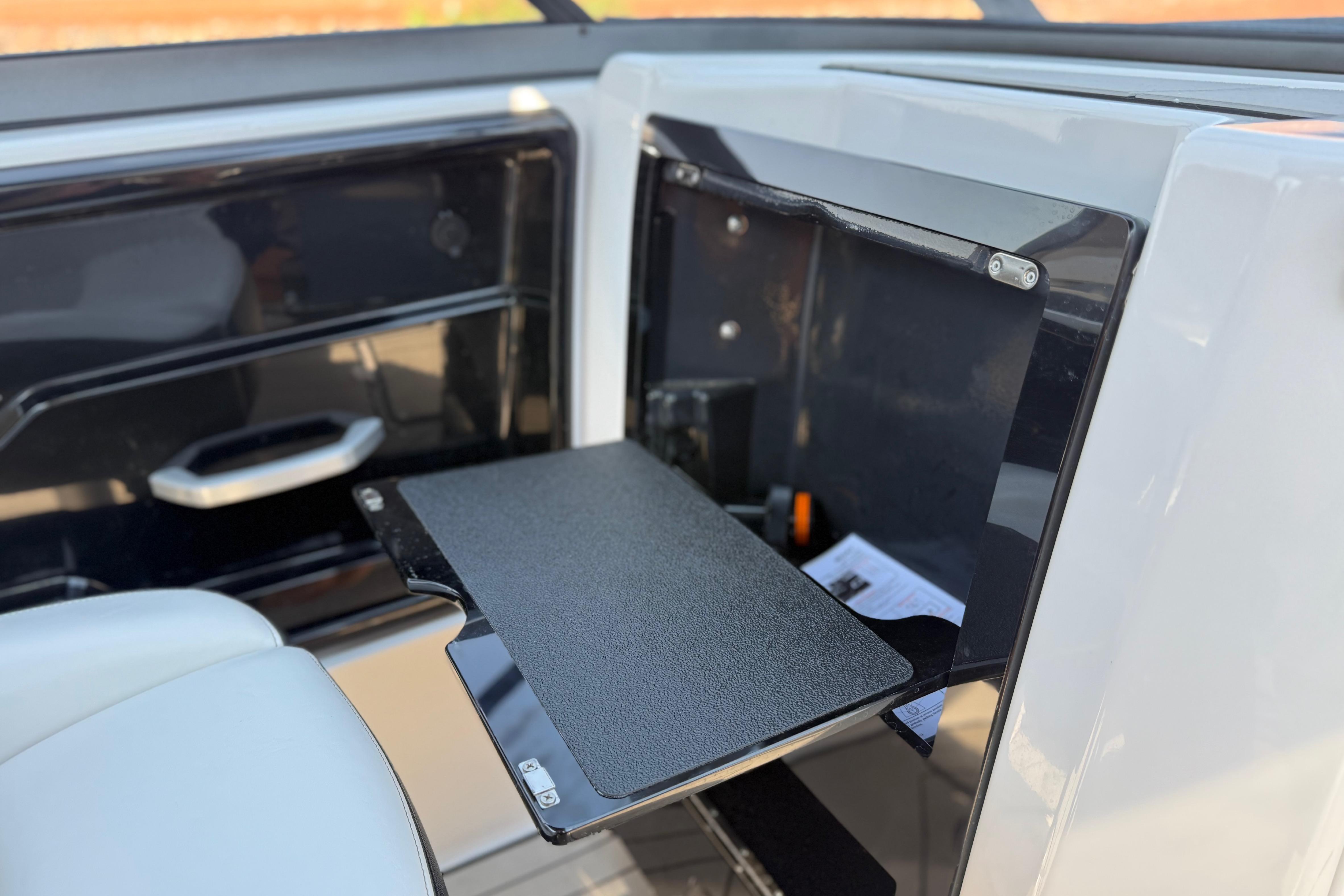2022 Yamaha Boats 212XE interior with fold-out table and storage compartment.