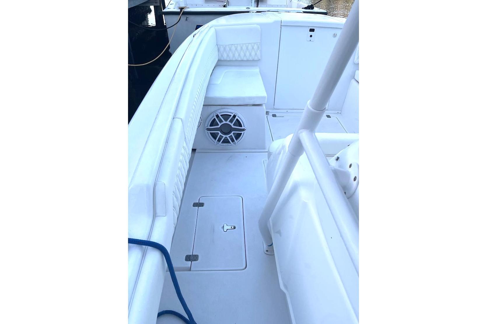 2002 Intrepid 323 Cuddy boat interior with white seating and storage compartments.