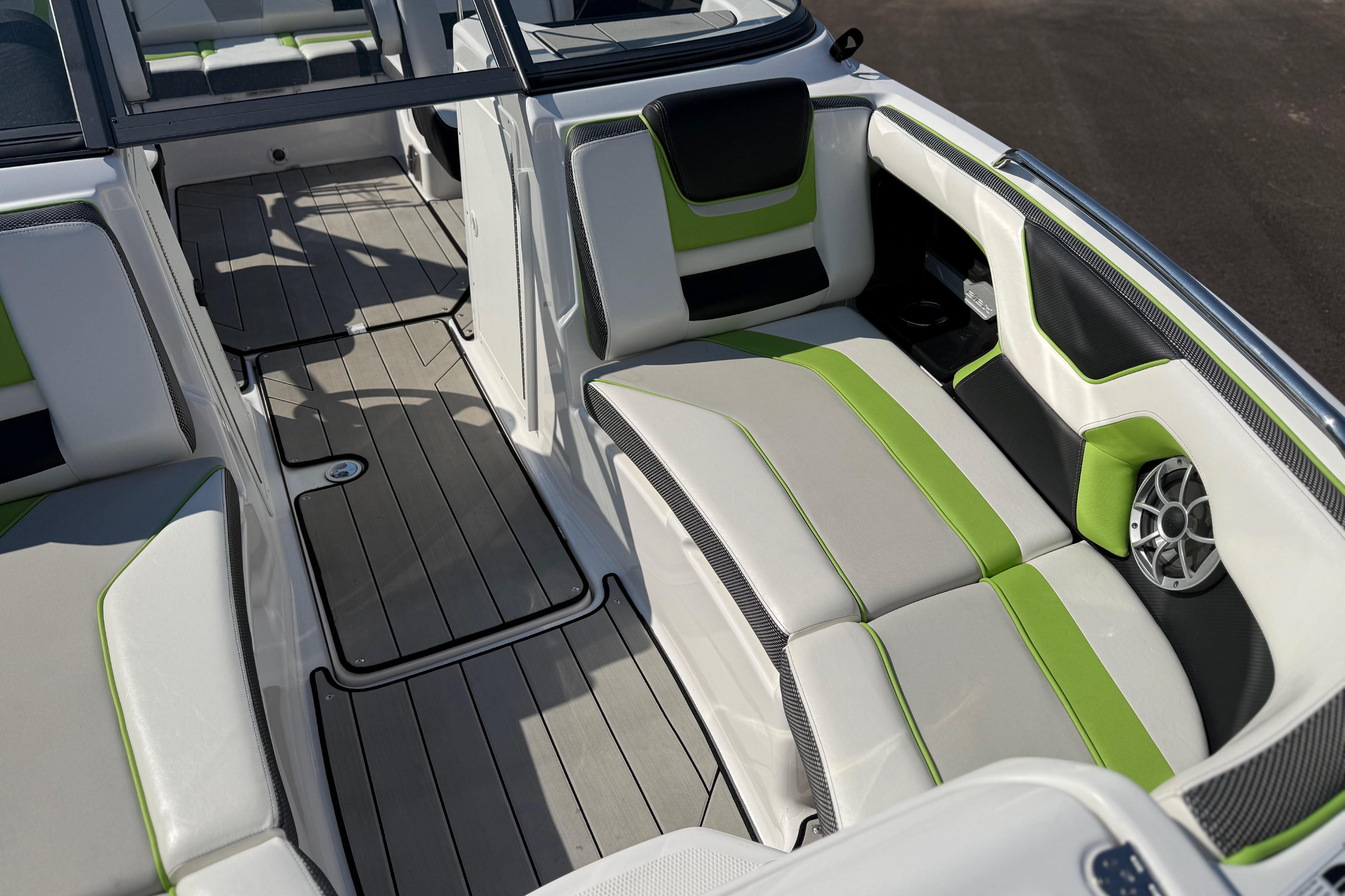 2022 Yamaha Boats 212XE interior with green and white seating, sleek design, and modern features.
