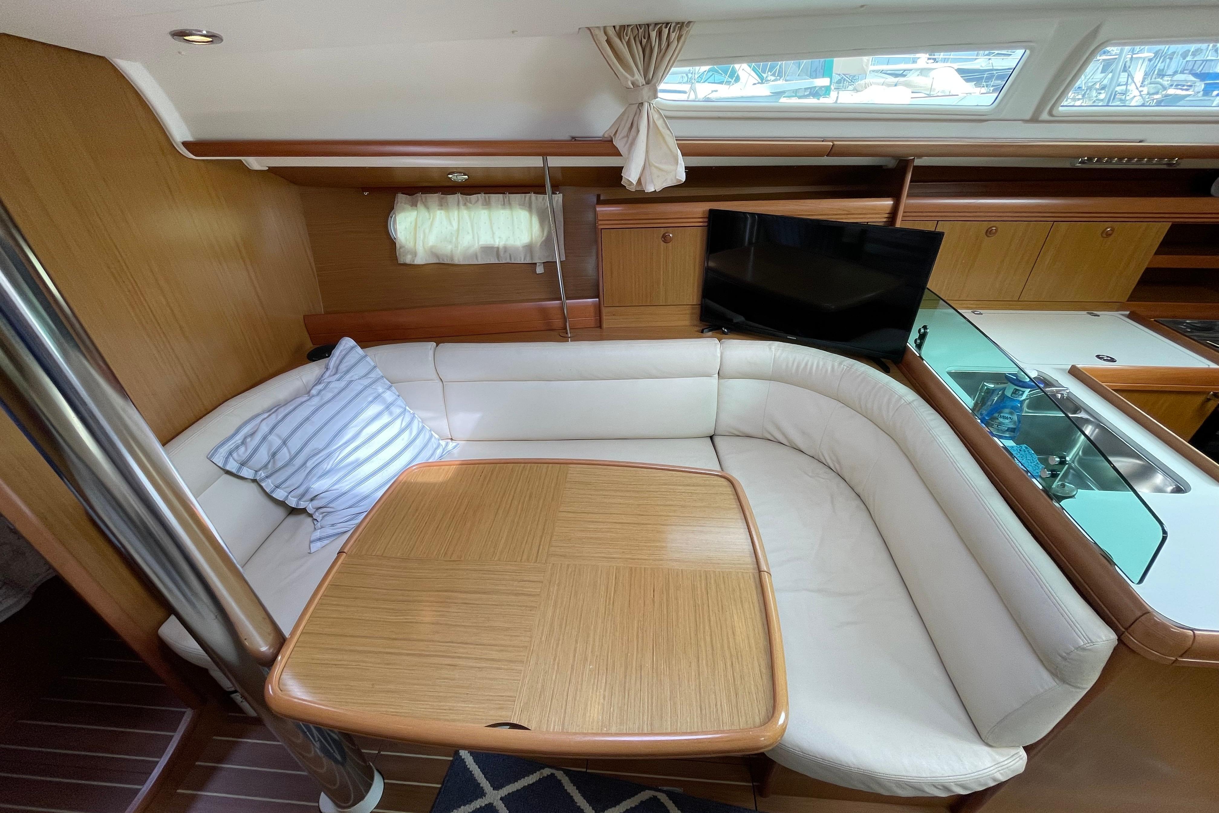 Interior of 2007 Jeanneau Sun Odyssey 39 DS yacht with cozy seating and table.