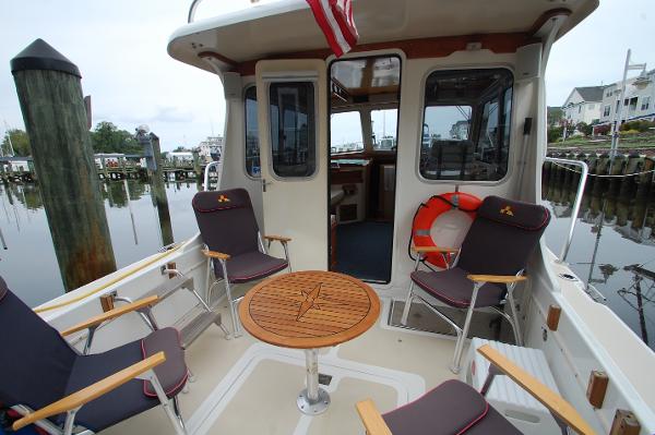 The image shows the stern of a 2005 Fox Island Thirty - Sedan Cruiser with seating and a table.