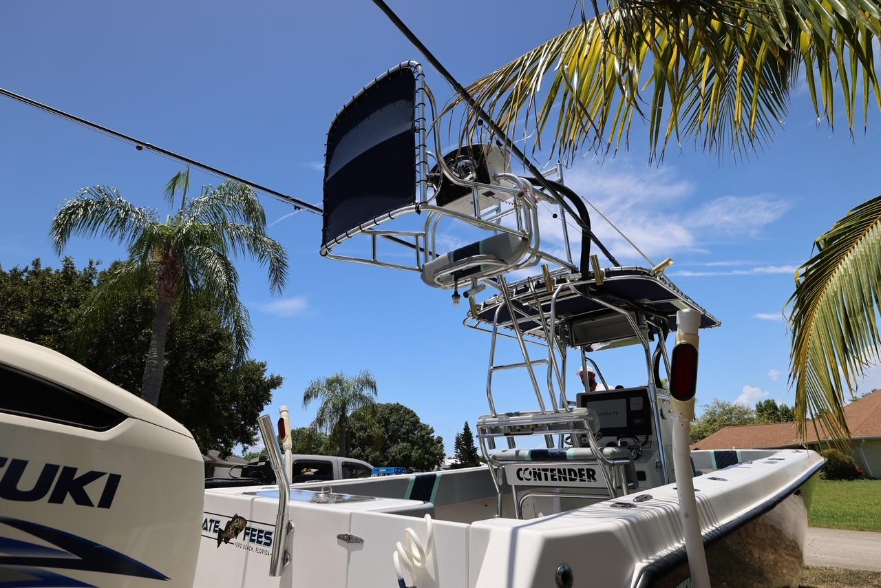 2001 Contender 27 Open boat with Suzuki engine under palm trees.