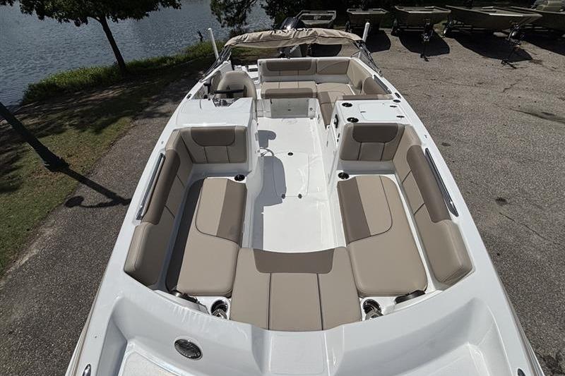 2026 Tahoe 2150 boat with spacious seating, docked near a serene lake.