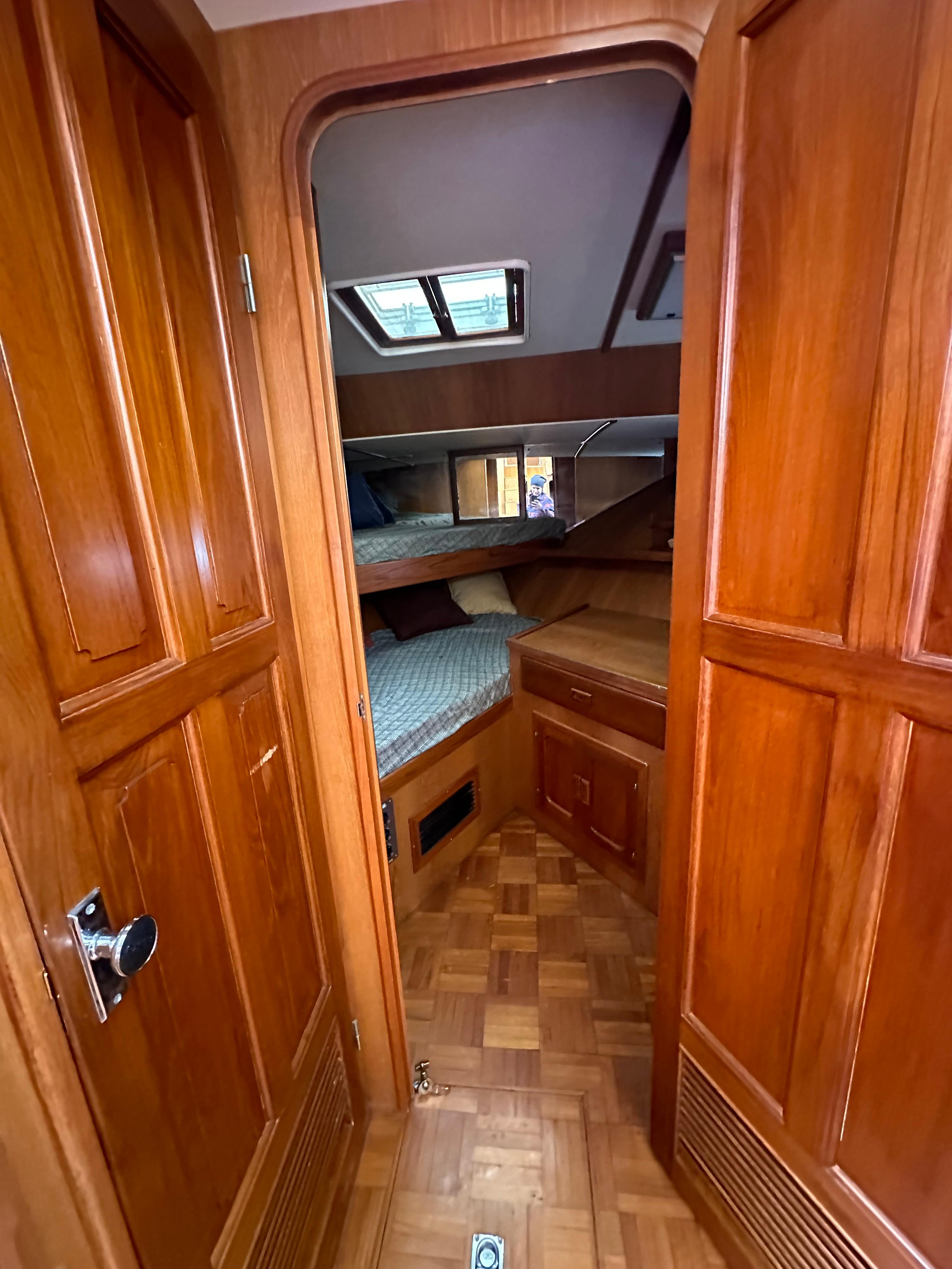 1988 Vista 43 Motor Yacht interior with wood paneling and cozy sleeping quarters.