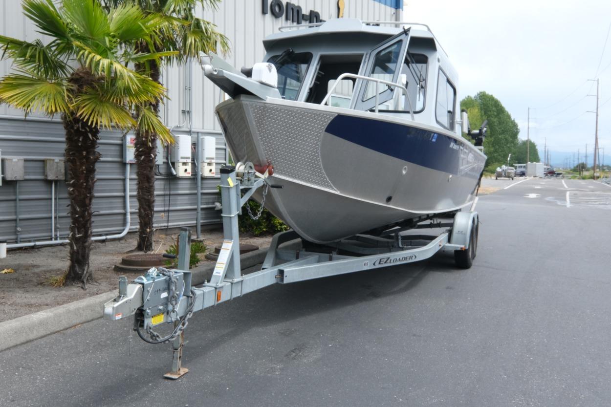 2021 Hewescraft 240 Ocean Pro ET Hardtop boat on trailer near palm trees.