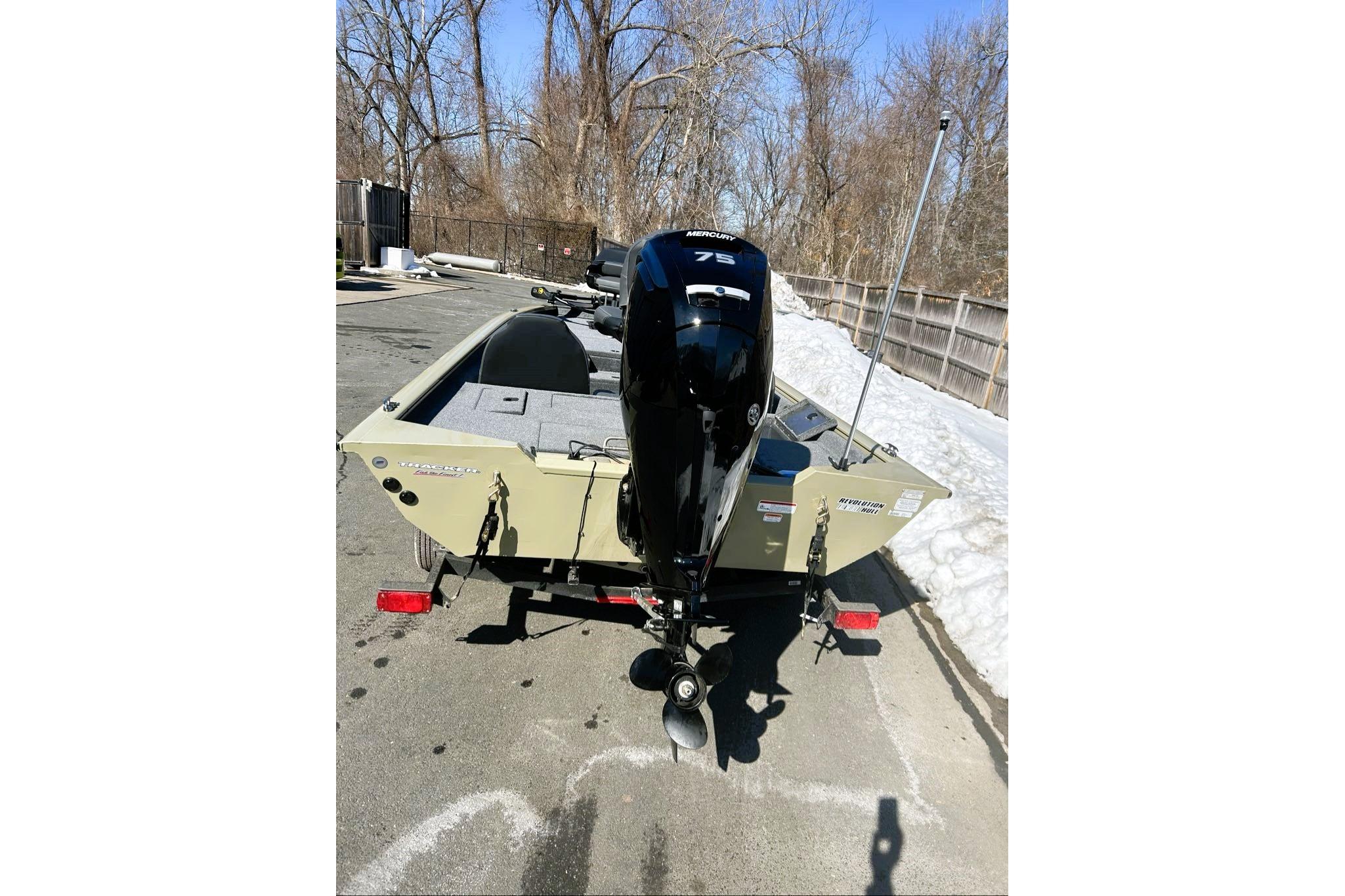 2026 Tracker Pro Team 175 boat with Mercury 75 engine, parked on snowy pavement.