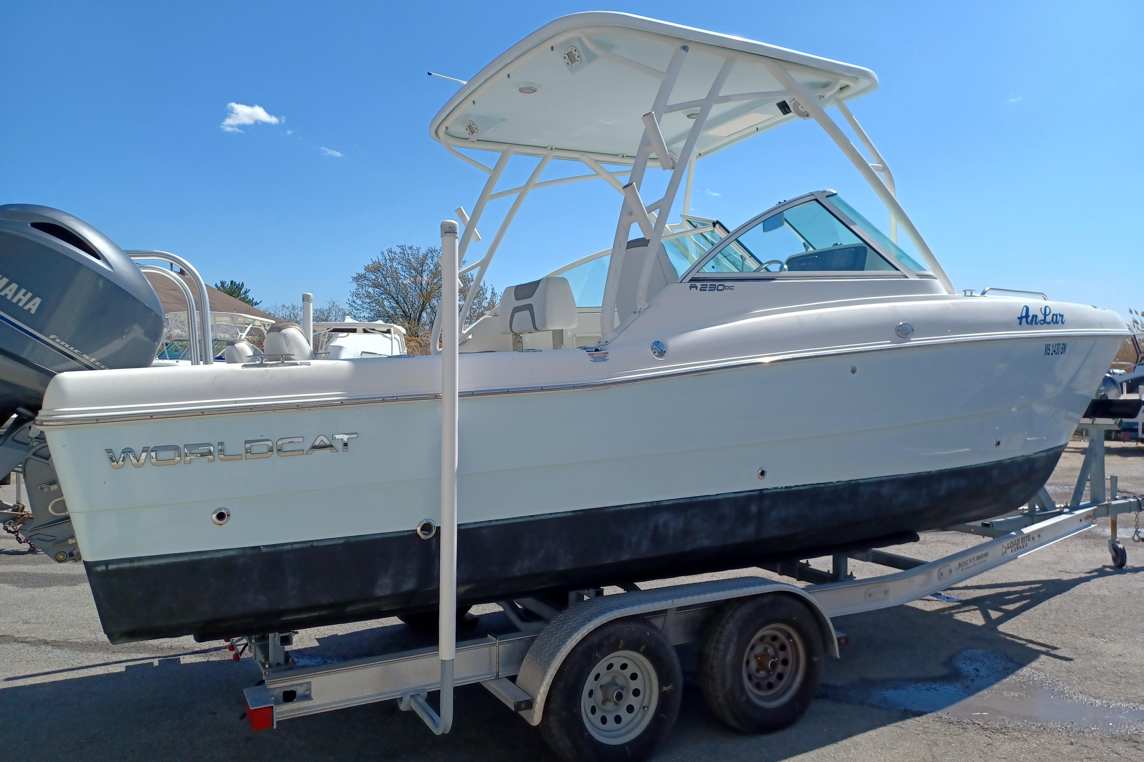 2020 World Cat 230 DC boat on trailer, side view under clear blue sky.