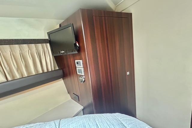 Interior of 2012 Monterey 400 Sport Yacht with TV and wooden cabinetry.