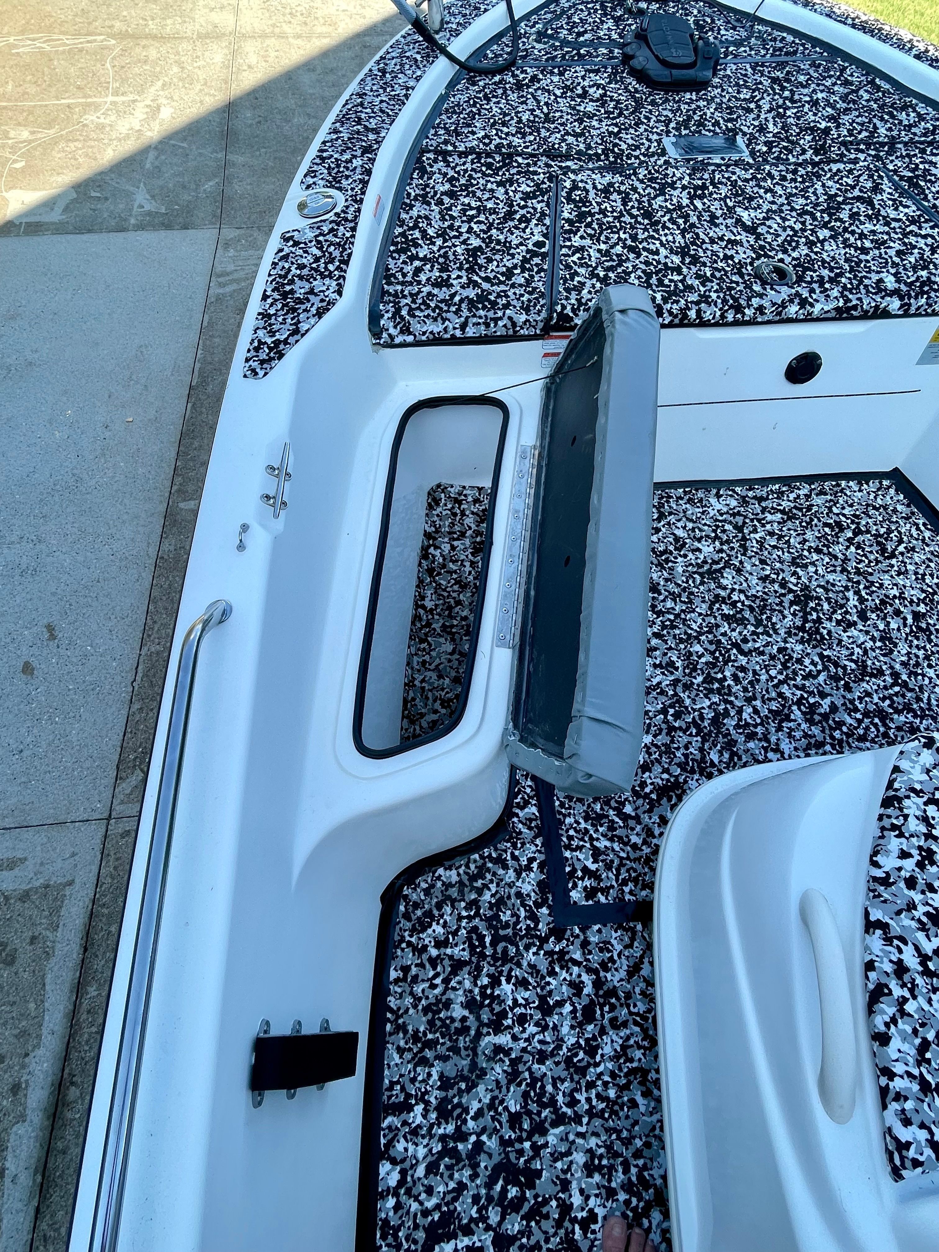 The image shows the deck of a 2006 Mako 2101 Inshore boat with an open storage compartment.