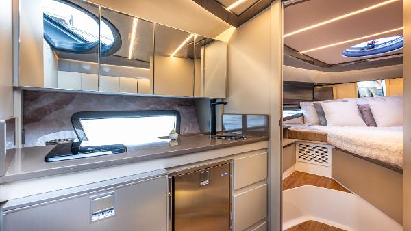 Luxurious interior of 2025 Hanover 415 yacht with modern kitchen and cozy bedroom.