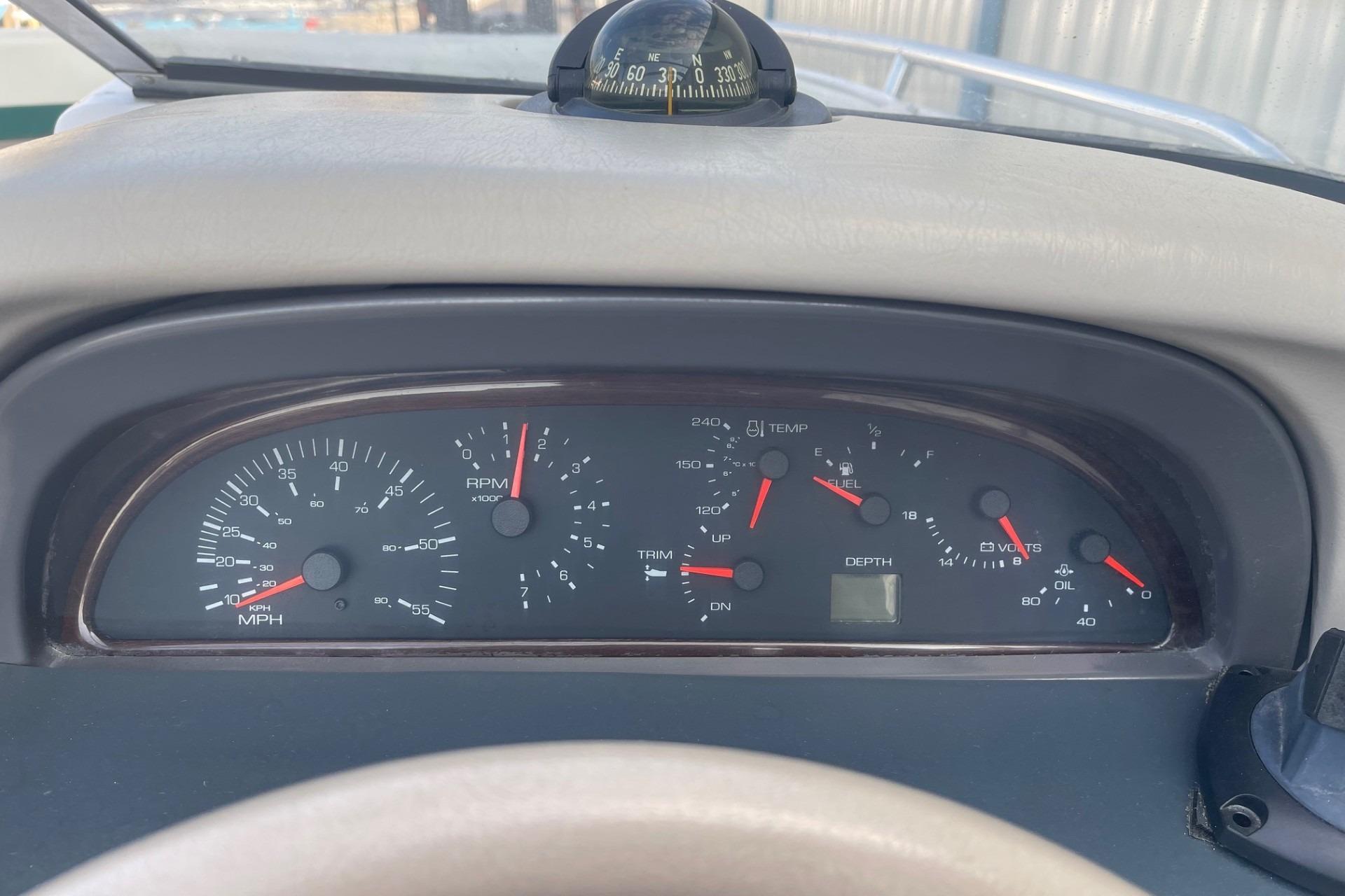 Dashboard of a 1996 Four Winns 200 Horizon boat with gauges and compass.