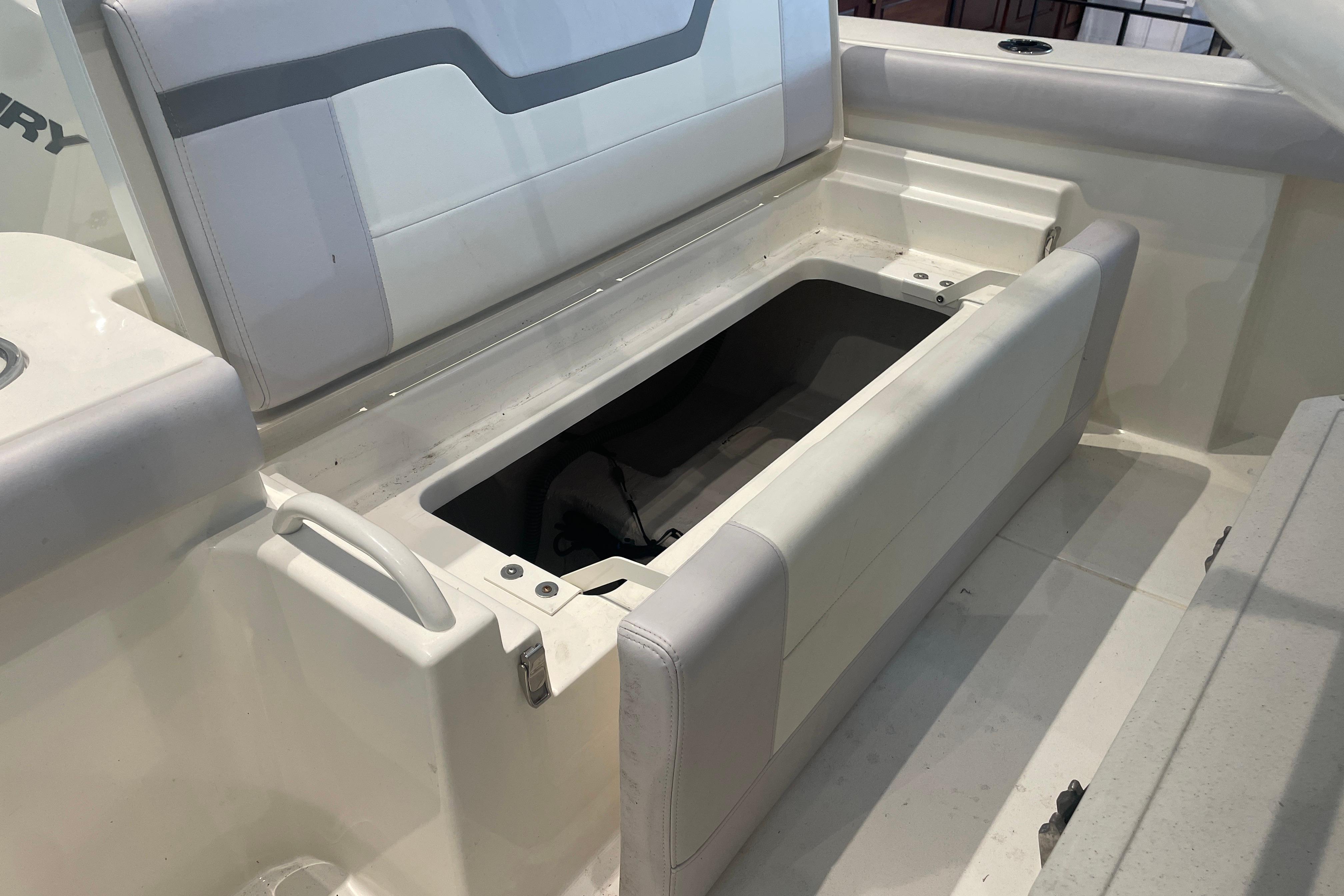 2026 Mako 226 Center Console boat with open storage compartment and cushioned seating.