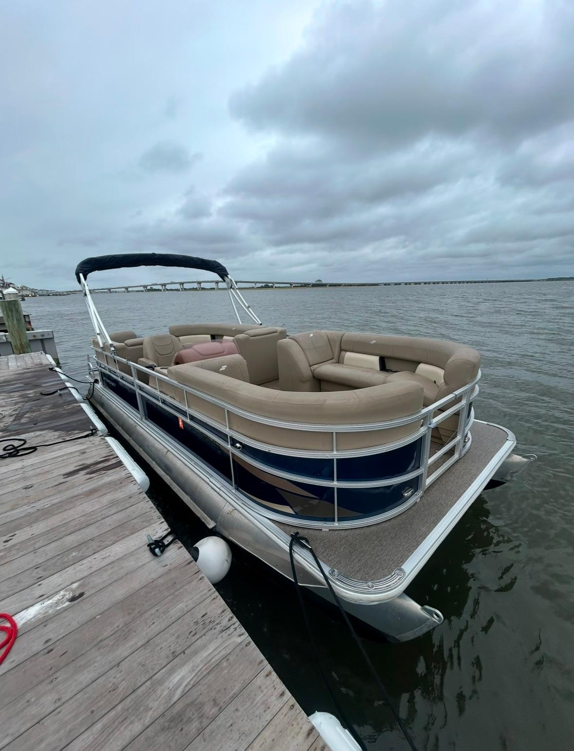 2022 Starcraft LX 22 R pontoon boat docked on a cloudy day.