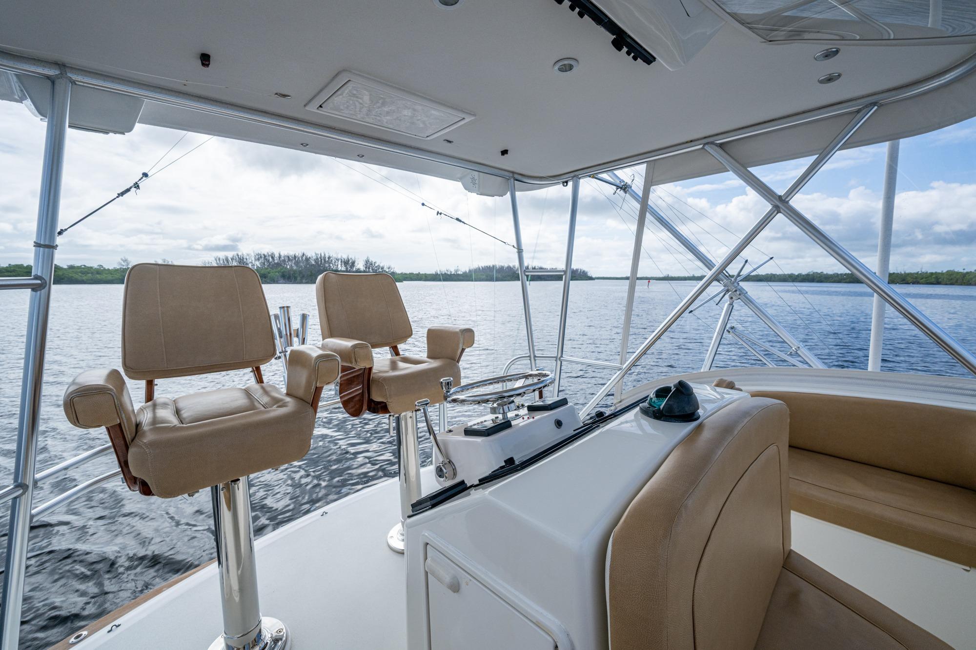 Interior view of 2008 Ocean Yachts 37 Billfish, featuring helm chairs and water backdrop.