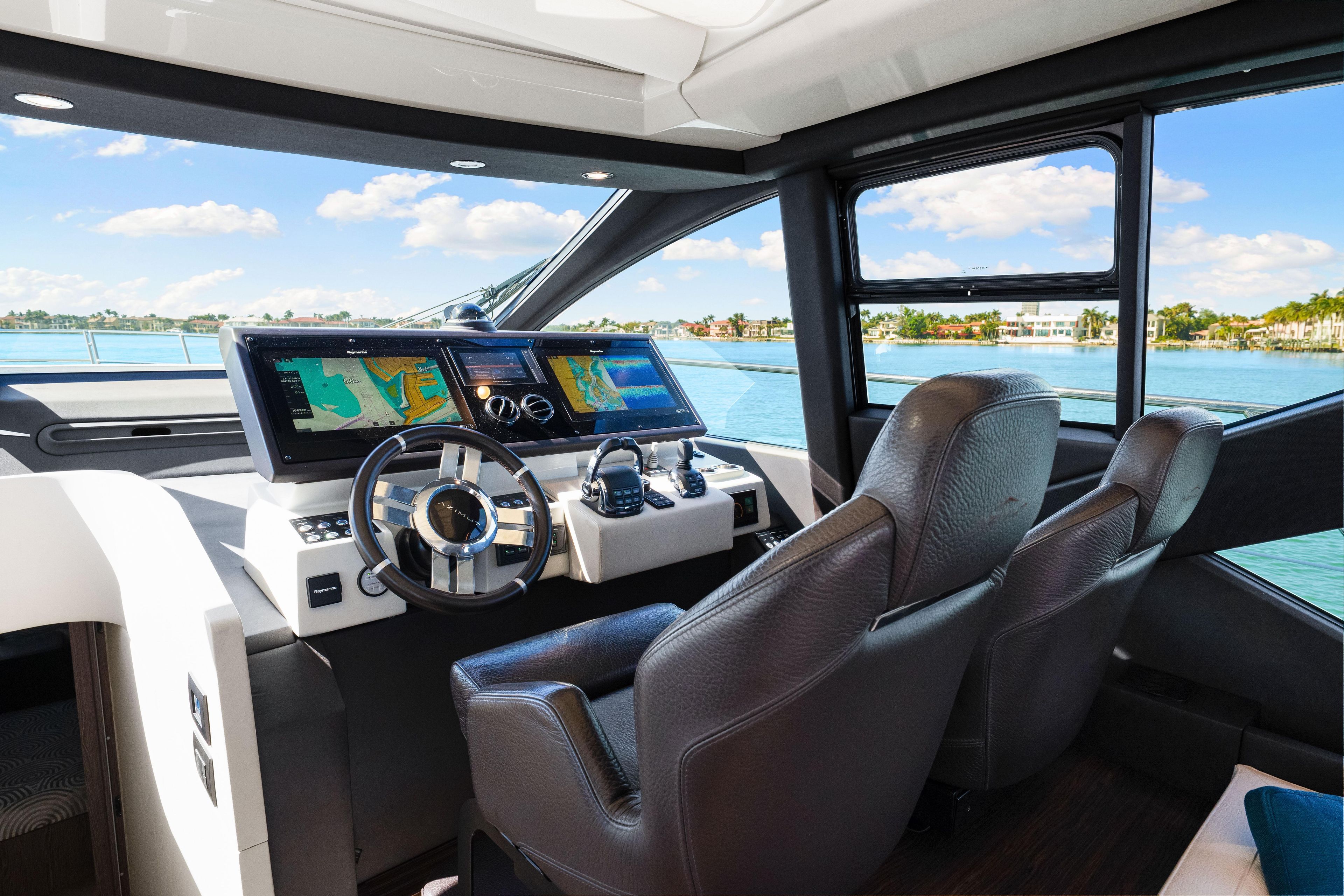 Interior view of 2020 Azimut S6 yacht cockpit with navigation screens and leather seats.