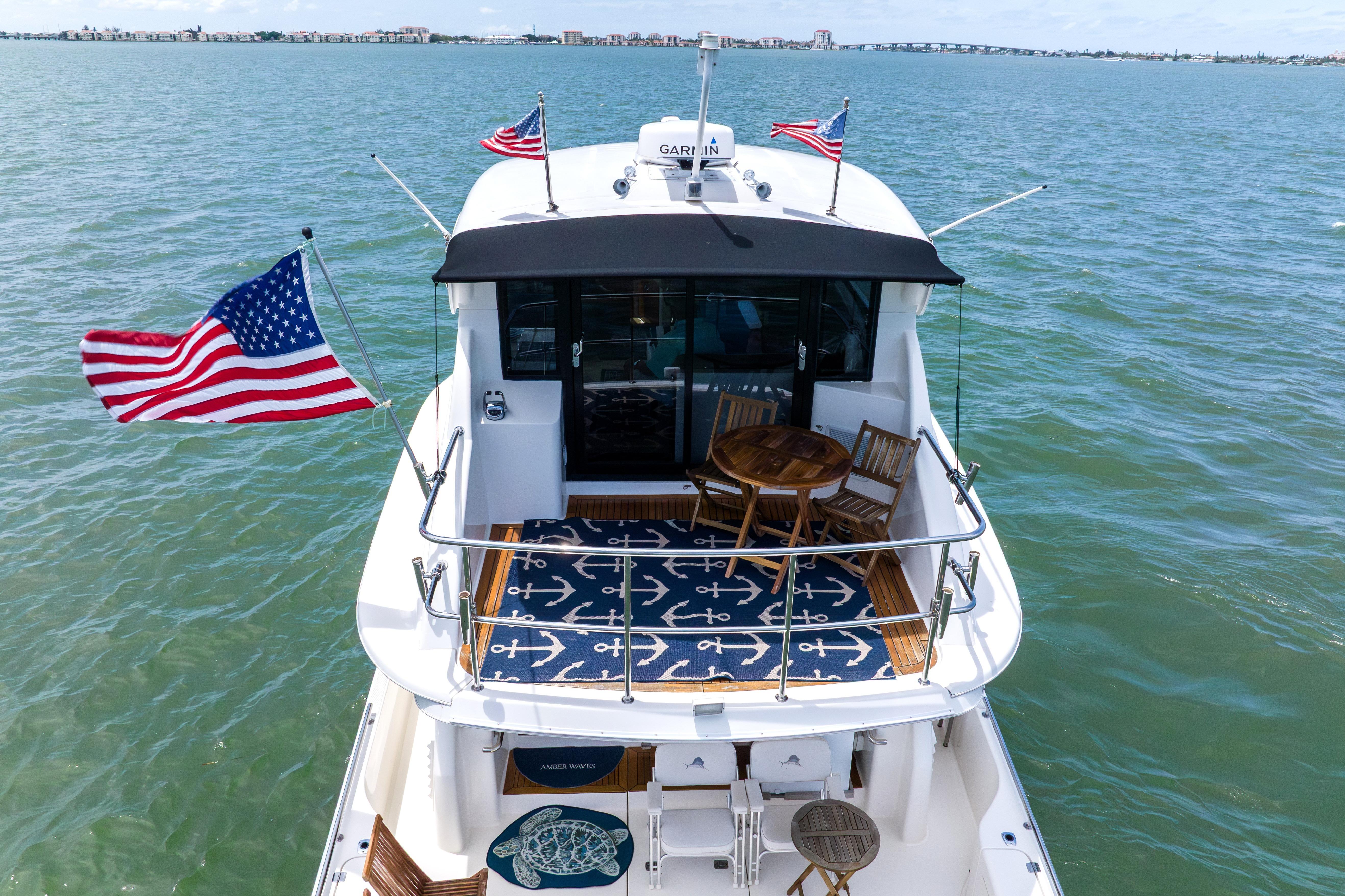 2008 Maritimo 52 yacht with American flags, featuring a deck with seating and nautical decor.