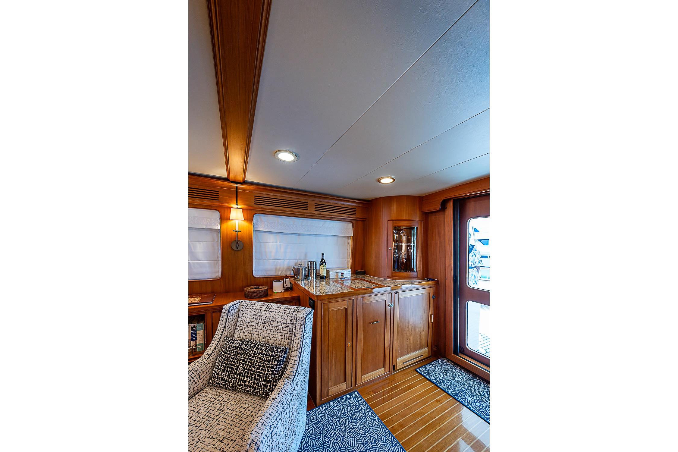 Luxurious interior of 2014 Marlow 80 Explorer yacht with wooden cabinetry and cozy seating.