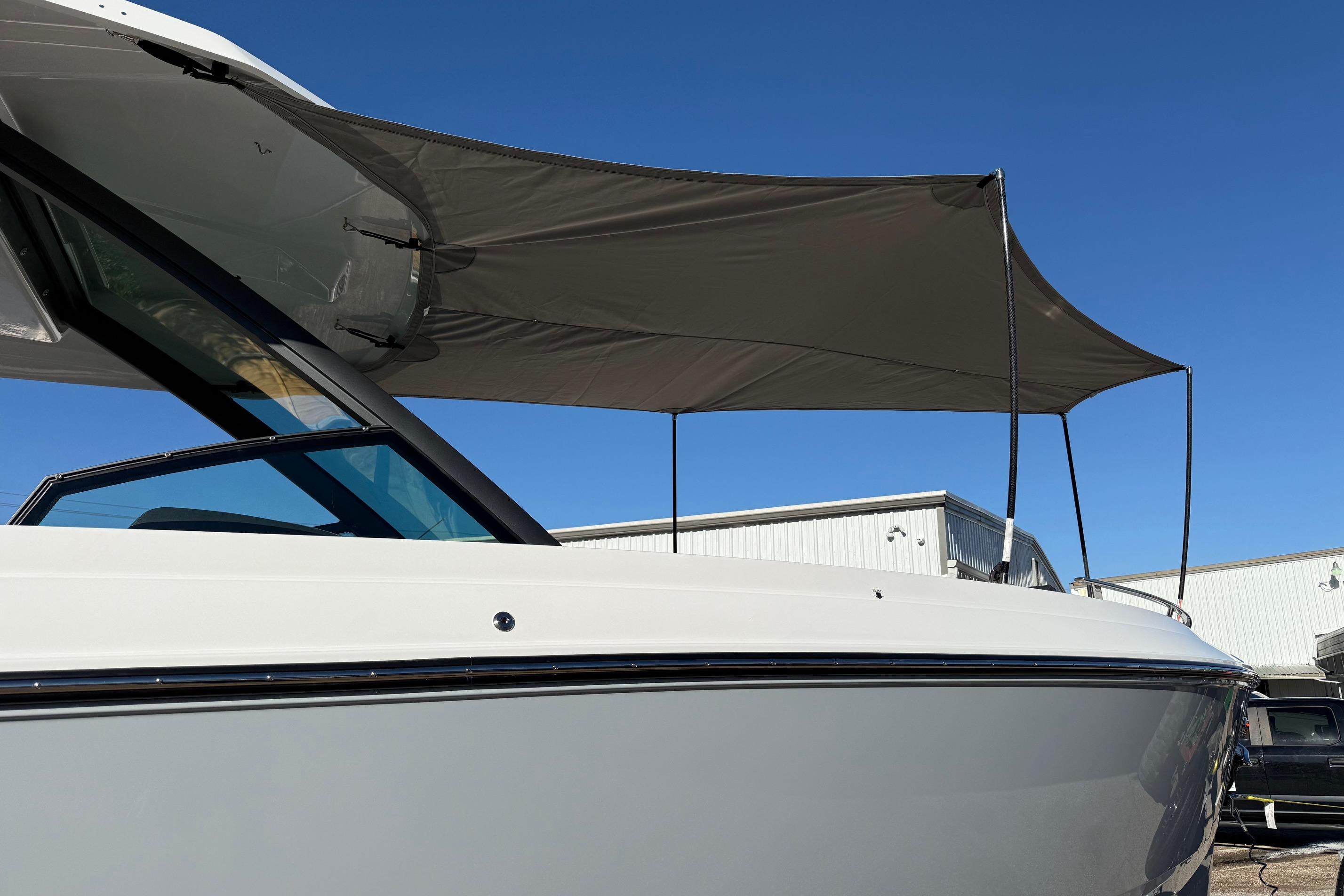 2026 Monterey Elite 30 OB with sunshade on deck.
