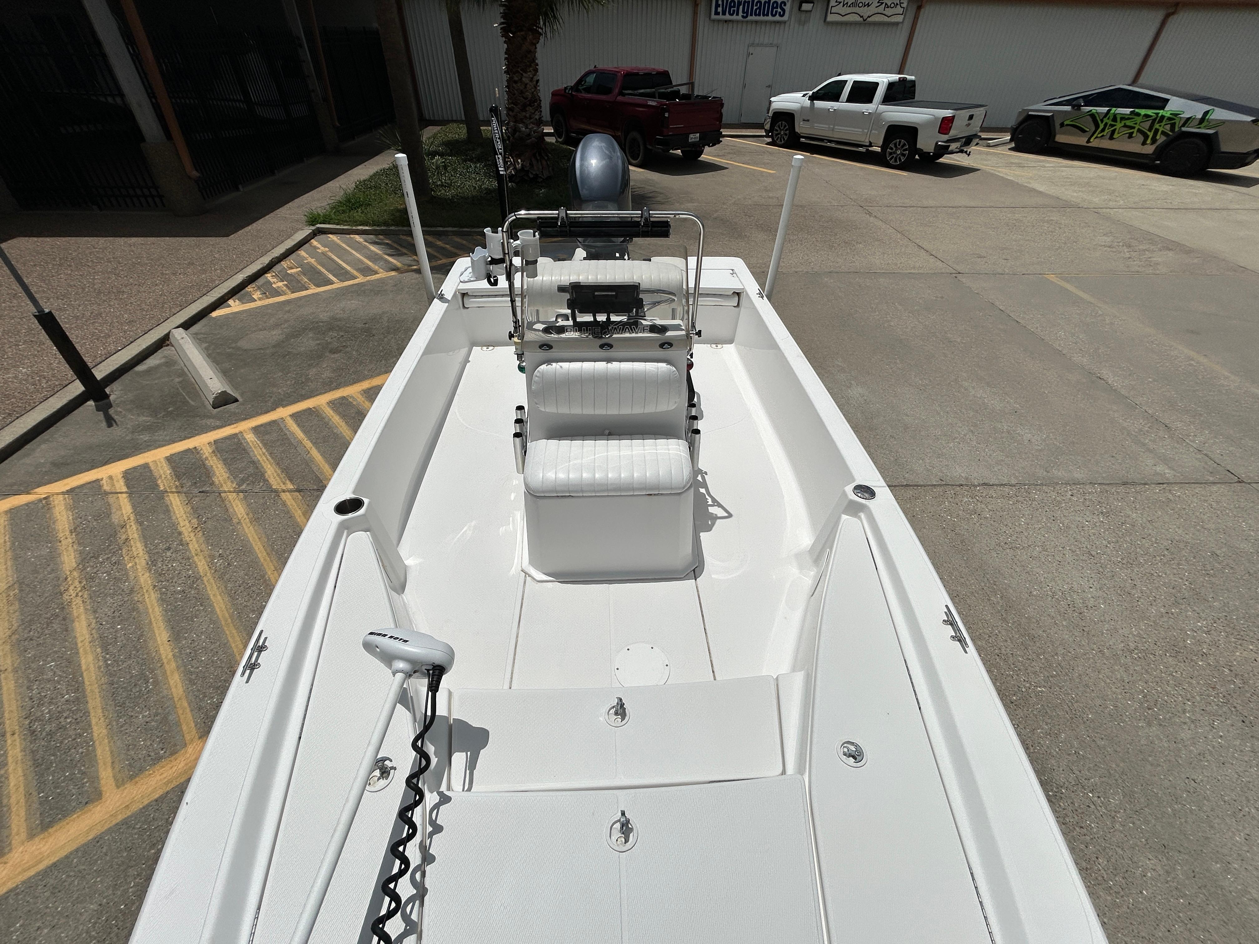 2012 Blue Wave 1900 STL boat interior with seating and controls, parked in a lot.
