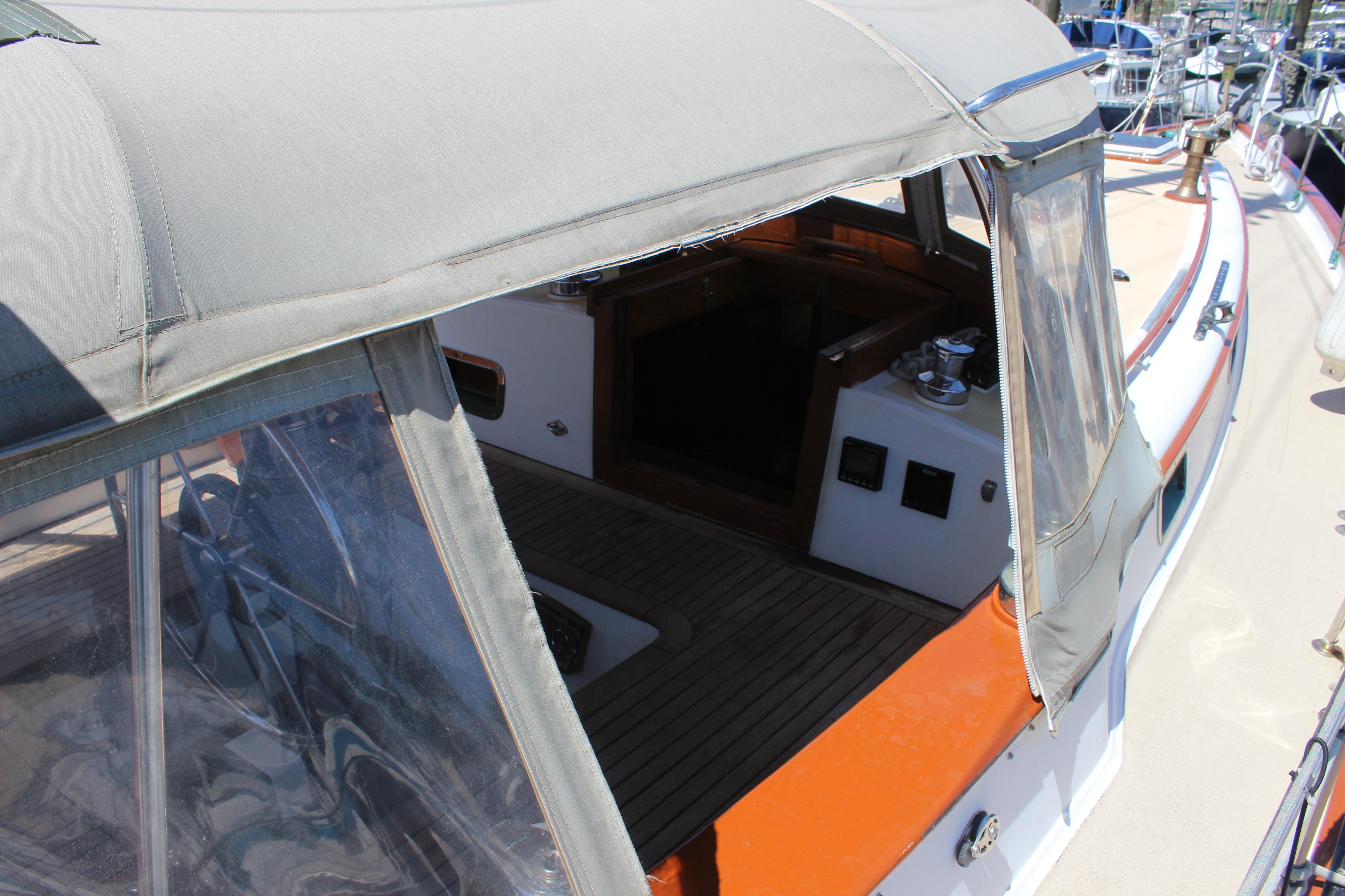 1981 Kelly Peterson 46 sailboat cockpit with canopy, docked at marina.