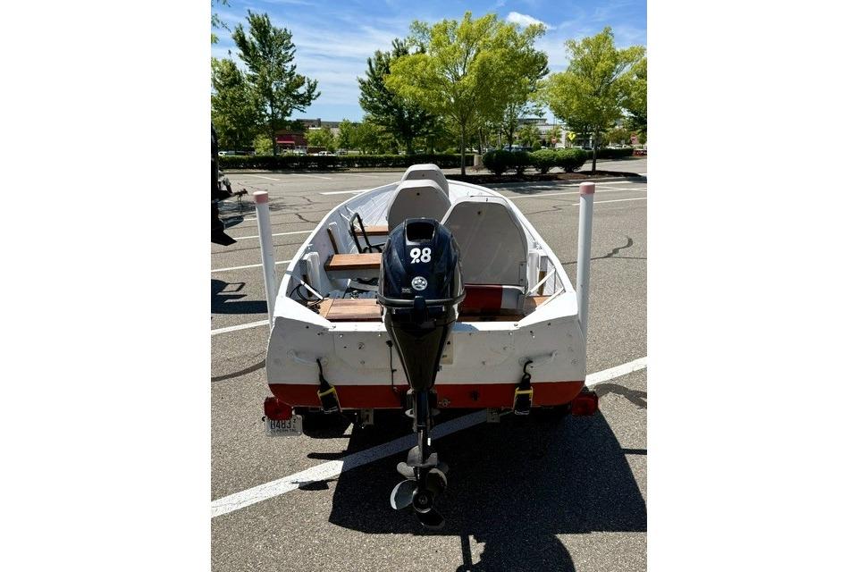 1958 Jon Boat Aluminum with outboard motor in a parking lot.